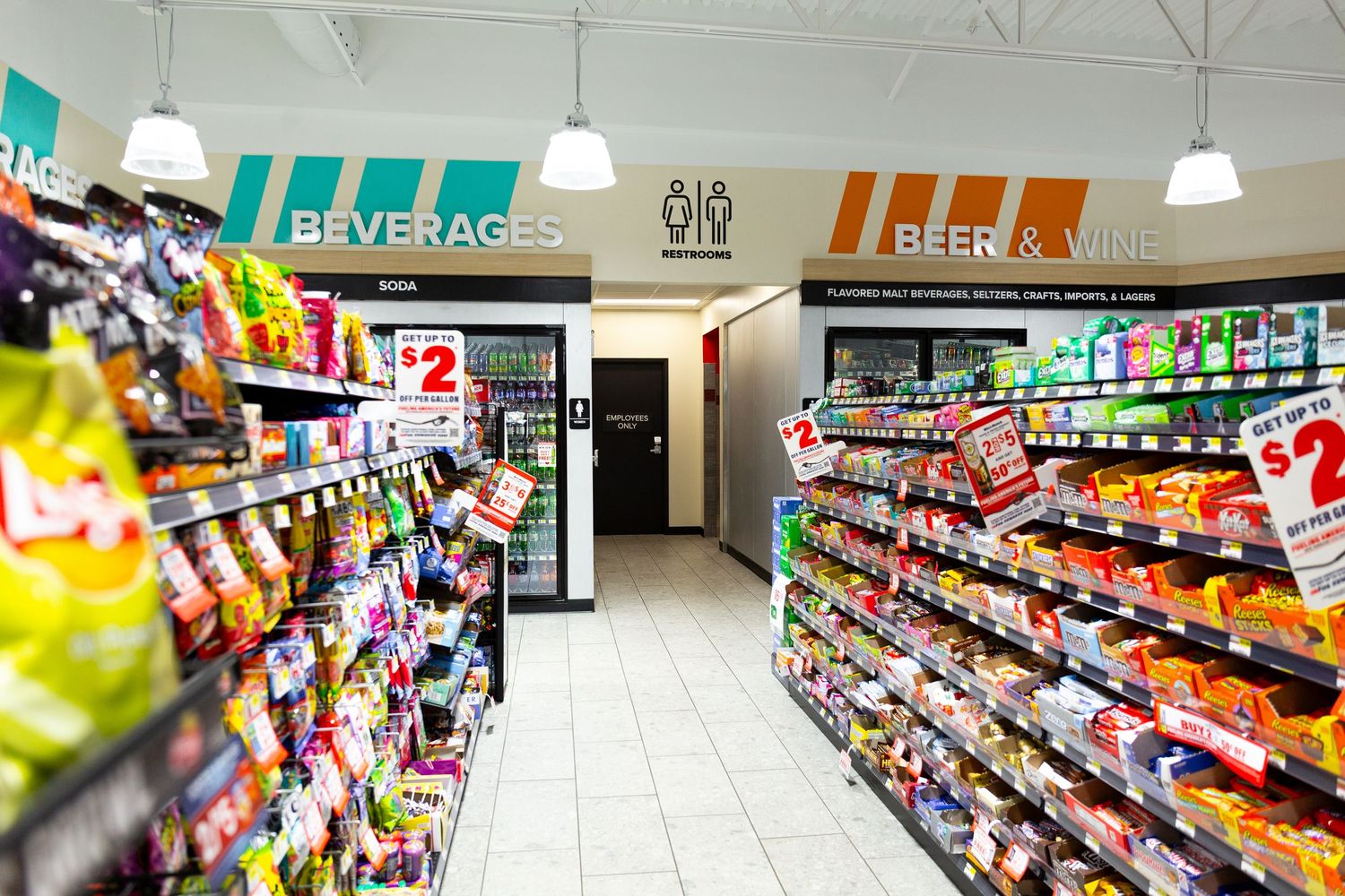 Grocery store interior showing multiple aisles stocked with beverages, snacks and food products on shelves.