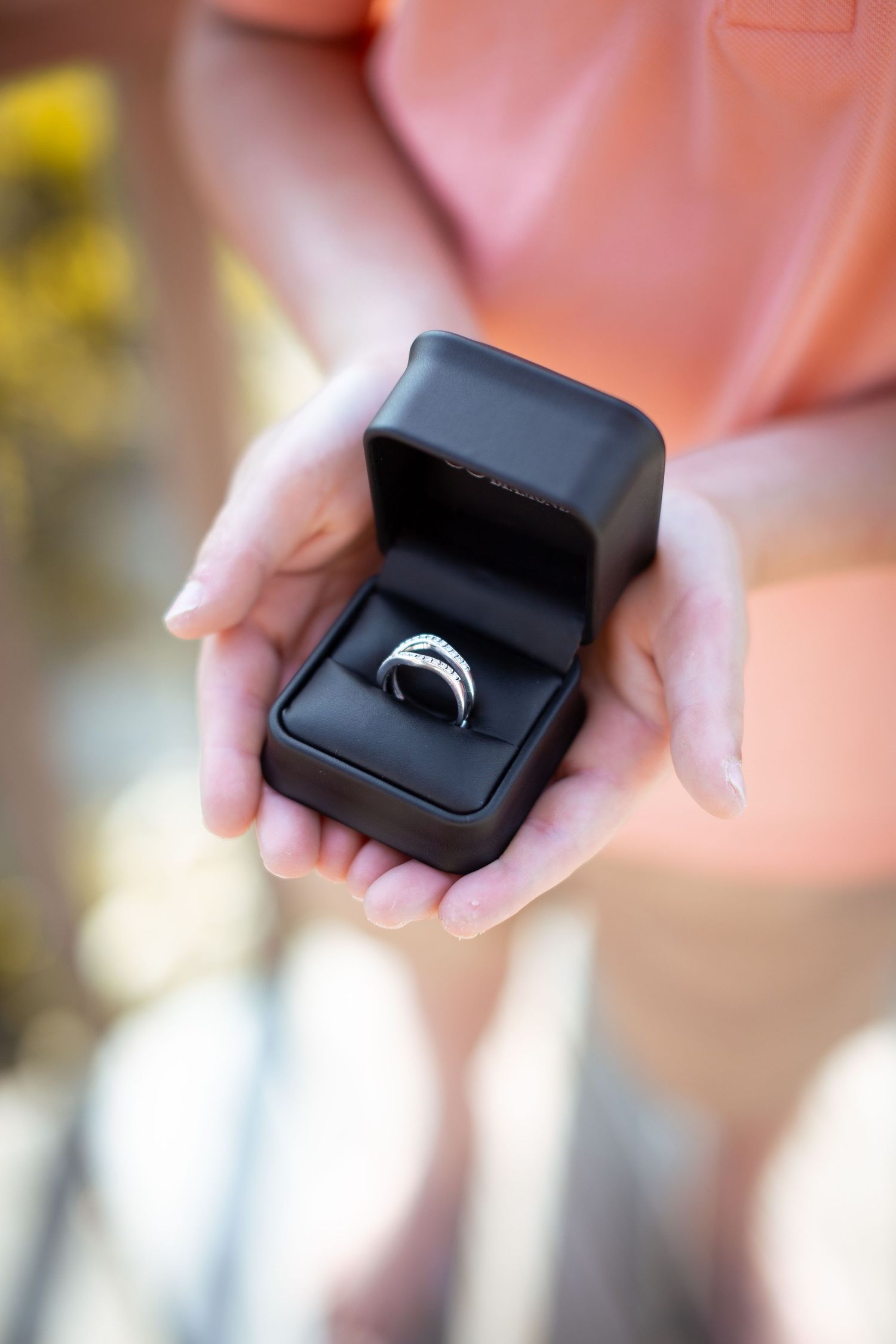 Close-up sequence showing a black ring box being opened to reveal an engagement ring.