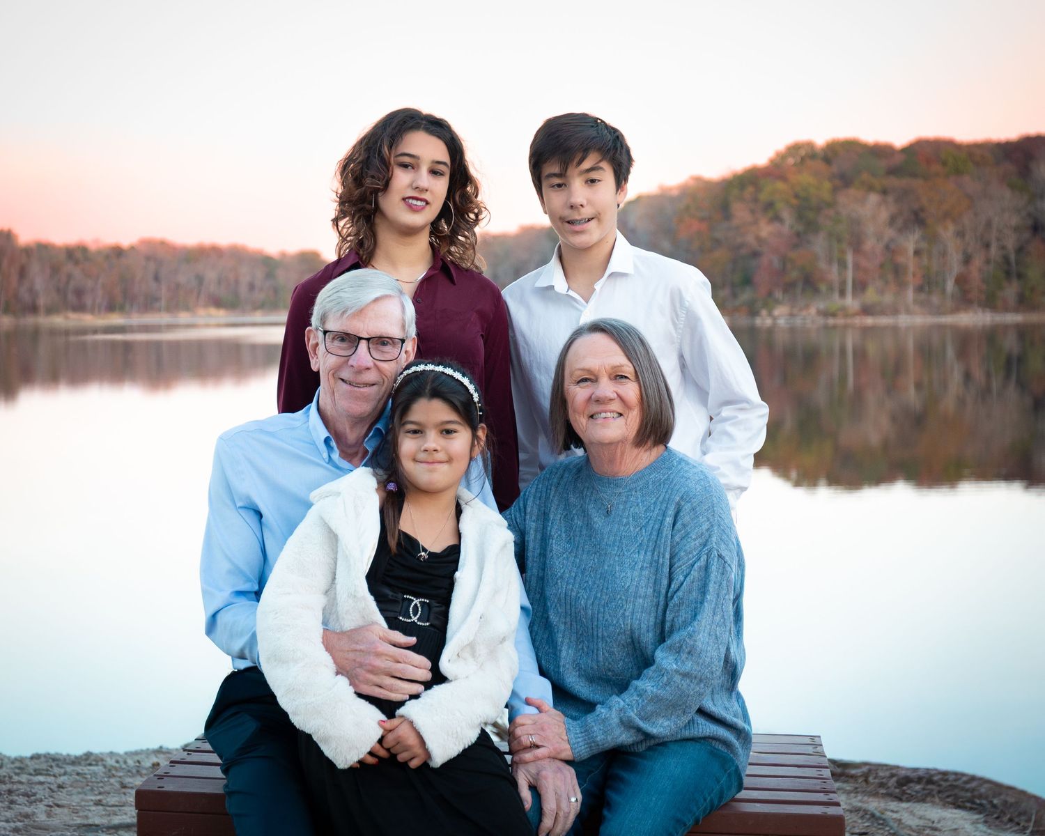Family portrait series with autumn foliage and lake backdrop.