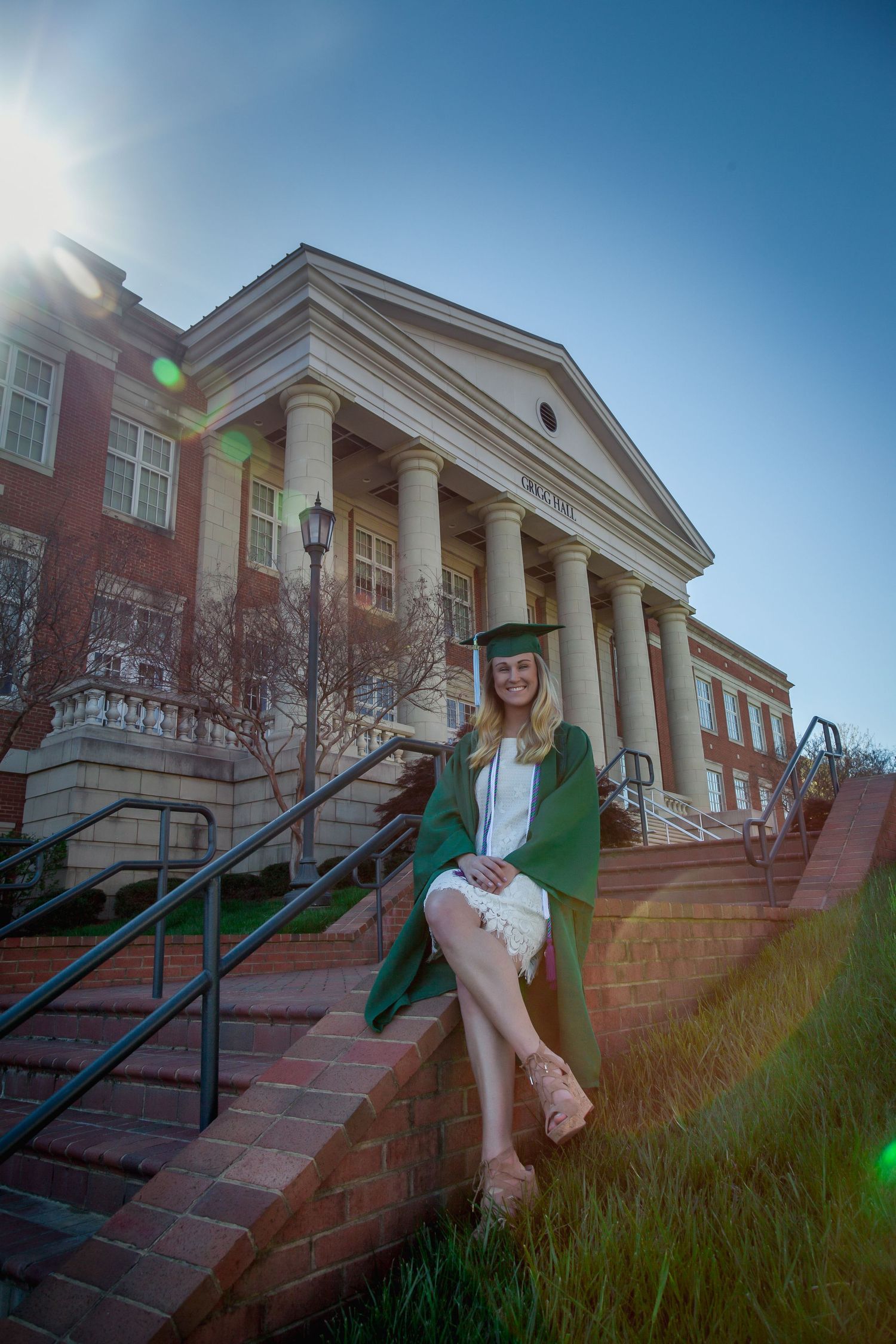 A series of graduation photos taken on brick steps leading up to a stately red brick building with white columns.