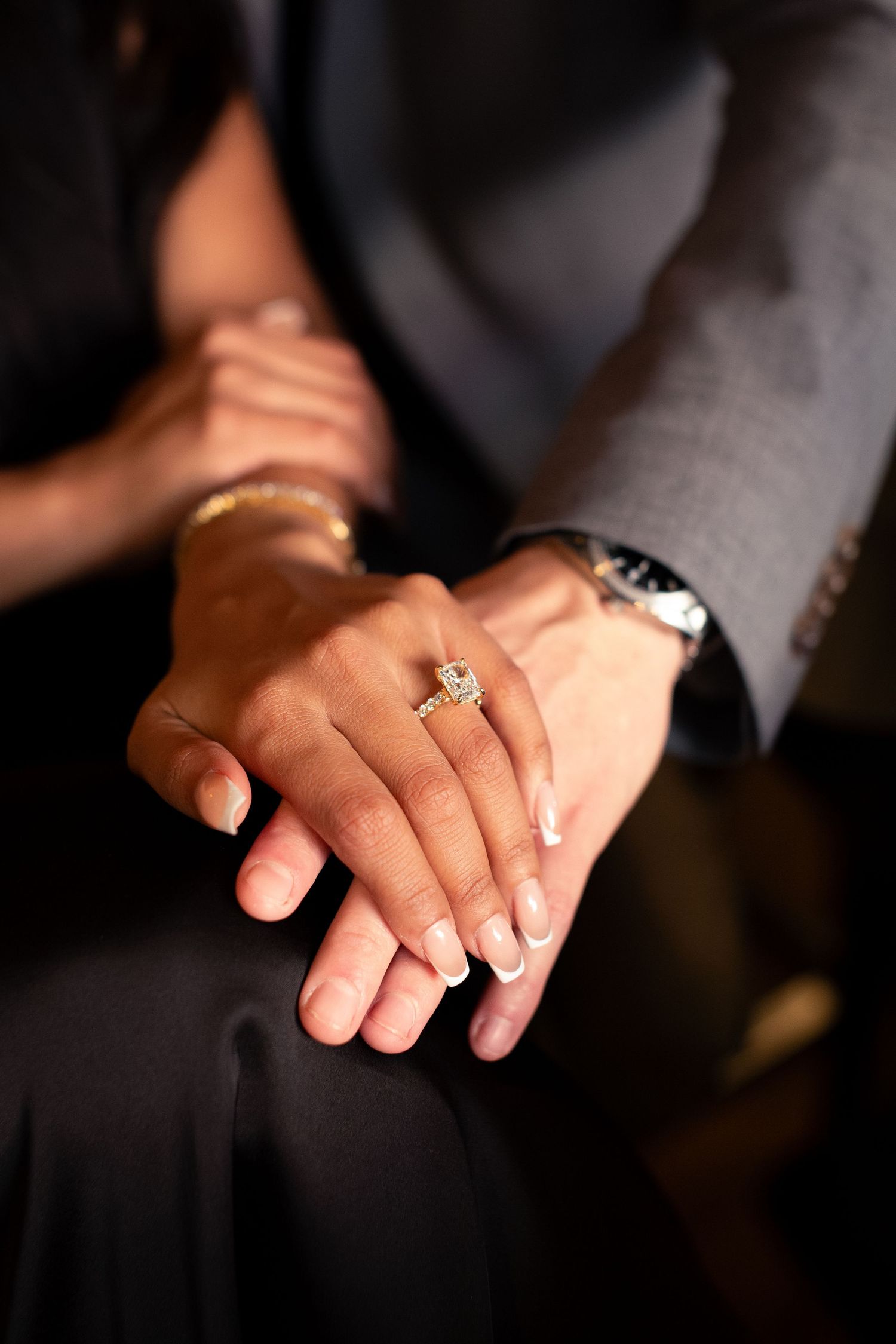 A close-up series showing a hand wearing an engagement ring with a sparkling diamond solitaire in different angles.