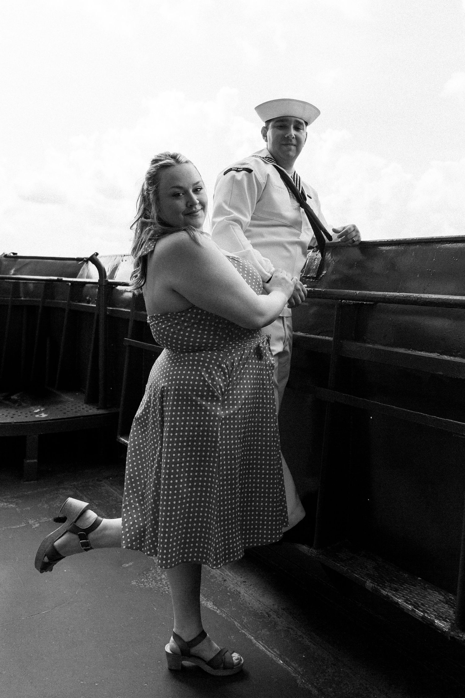 A black and white photo series shows a person in a polka dot dress dancing and twirling on a rooftop.