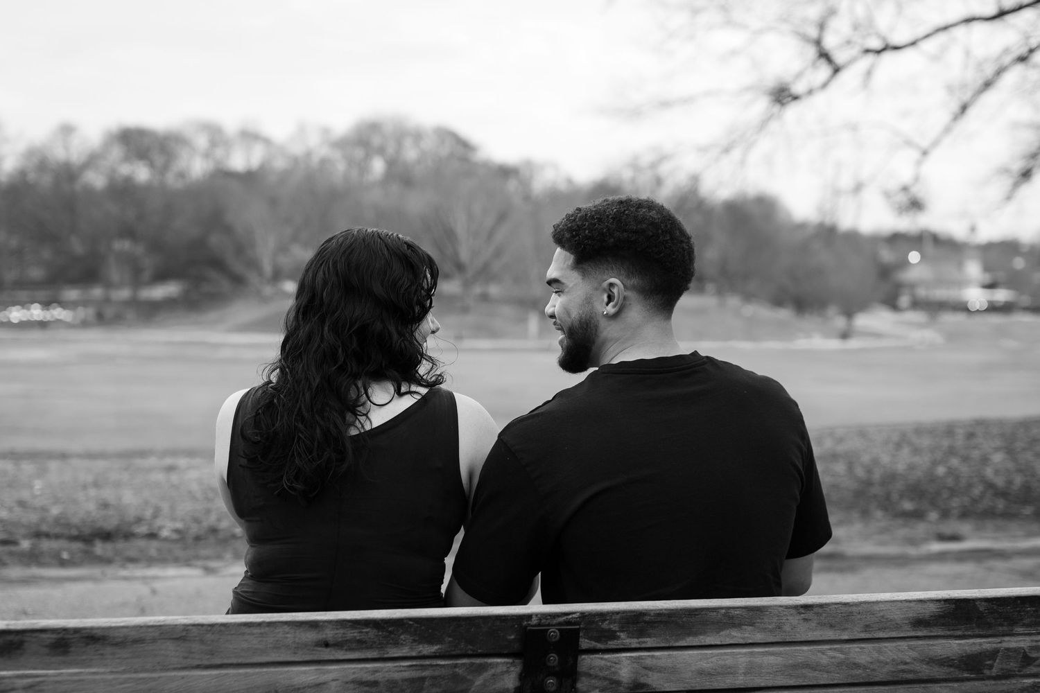 A series of black and white silhouettes show a couple sitting together on a bench in various romantic poses.