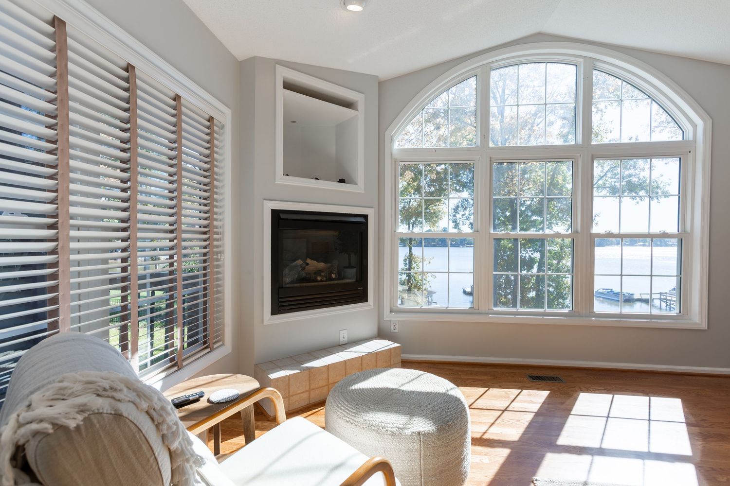 Bright living space with arched windows, white trim, and natural light illuminating the interior design.