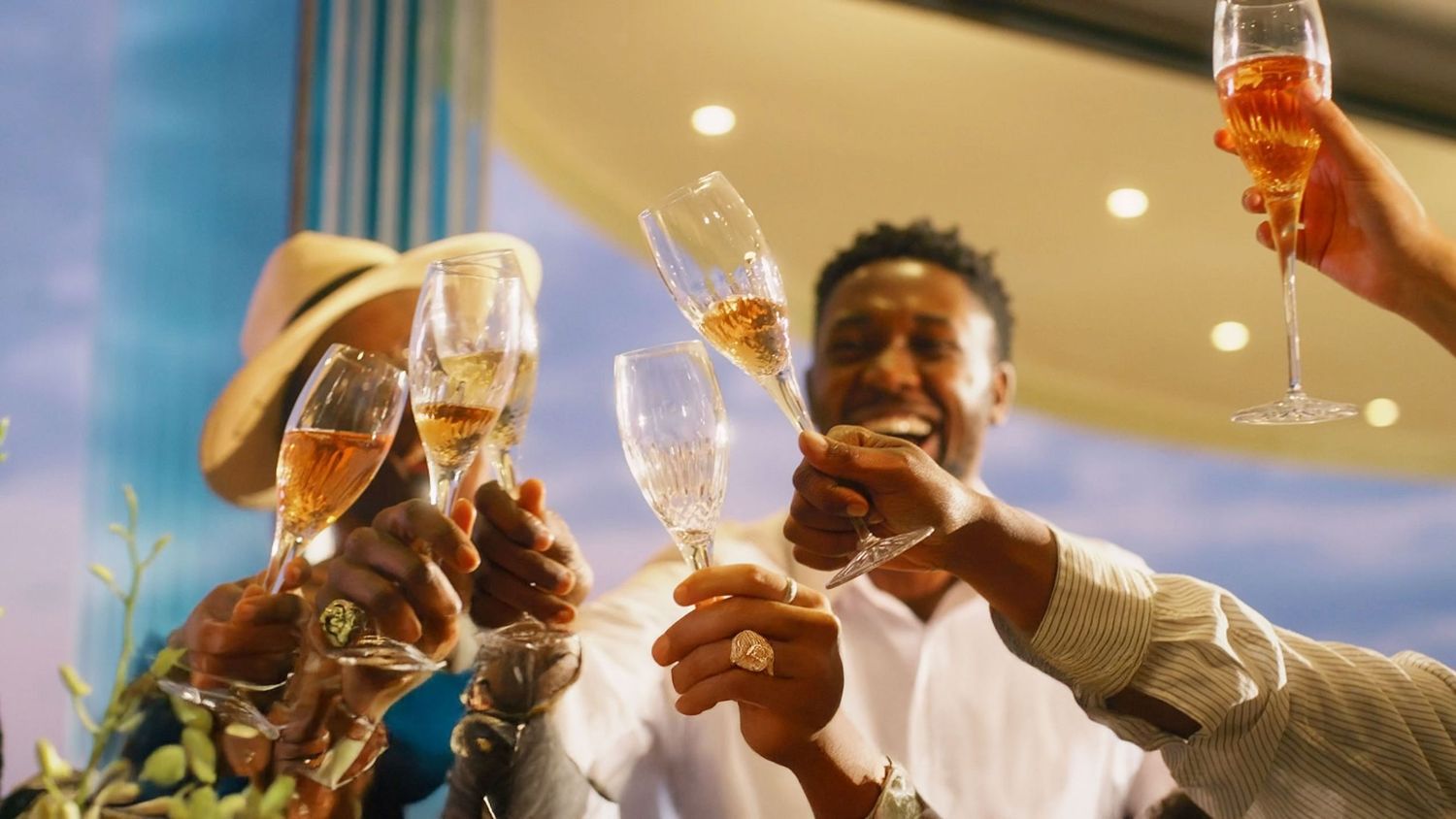 Diverse group of guests joyfully toasting with champagne glasses at a celebratory event.