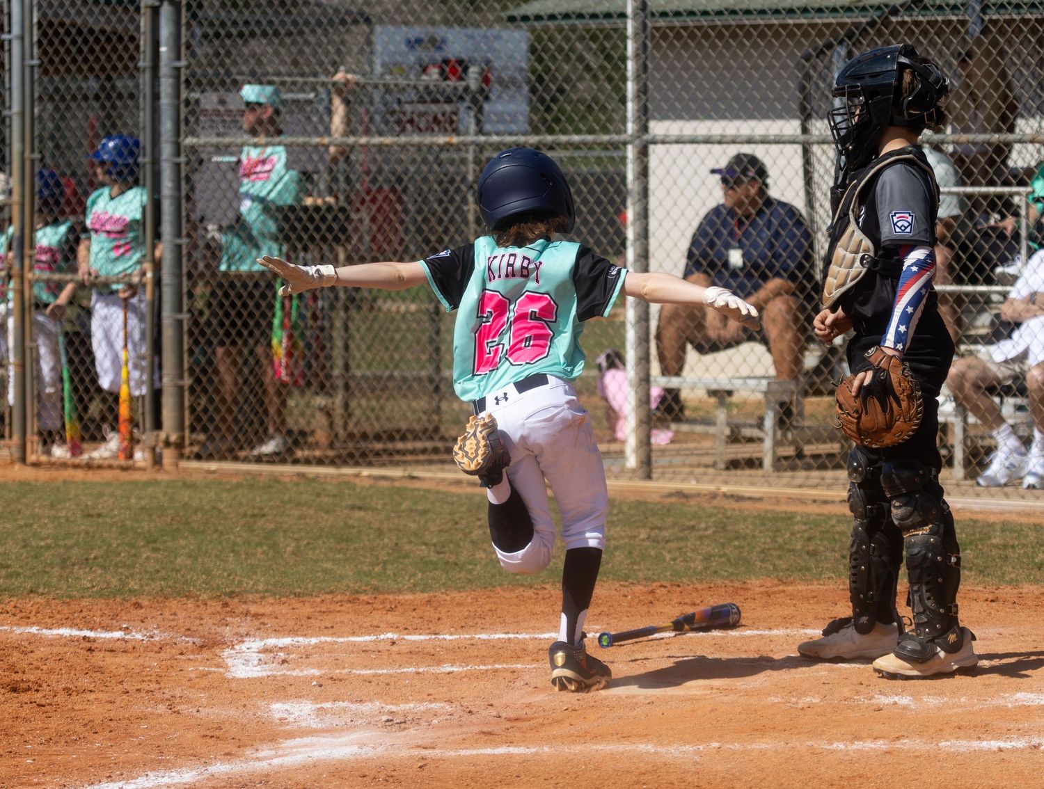 Baseball players in action during a youth league game with multiple batting stances and swings shown.