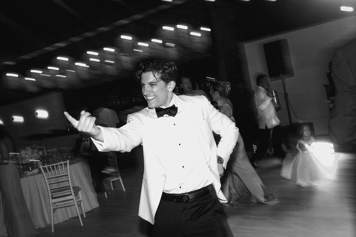 Black and white photo of a wedding reception with dancing and celebration.