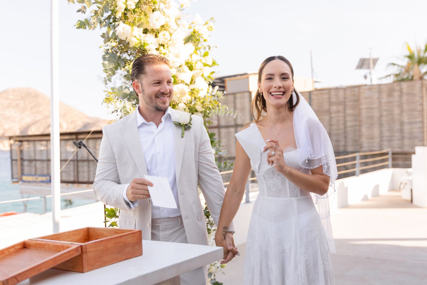A couple shares a laugh during their wedding celebration outdoors.