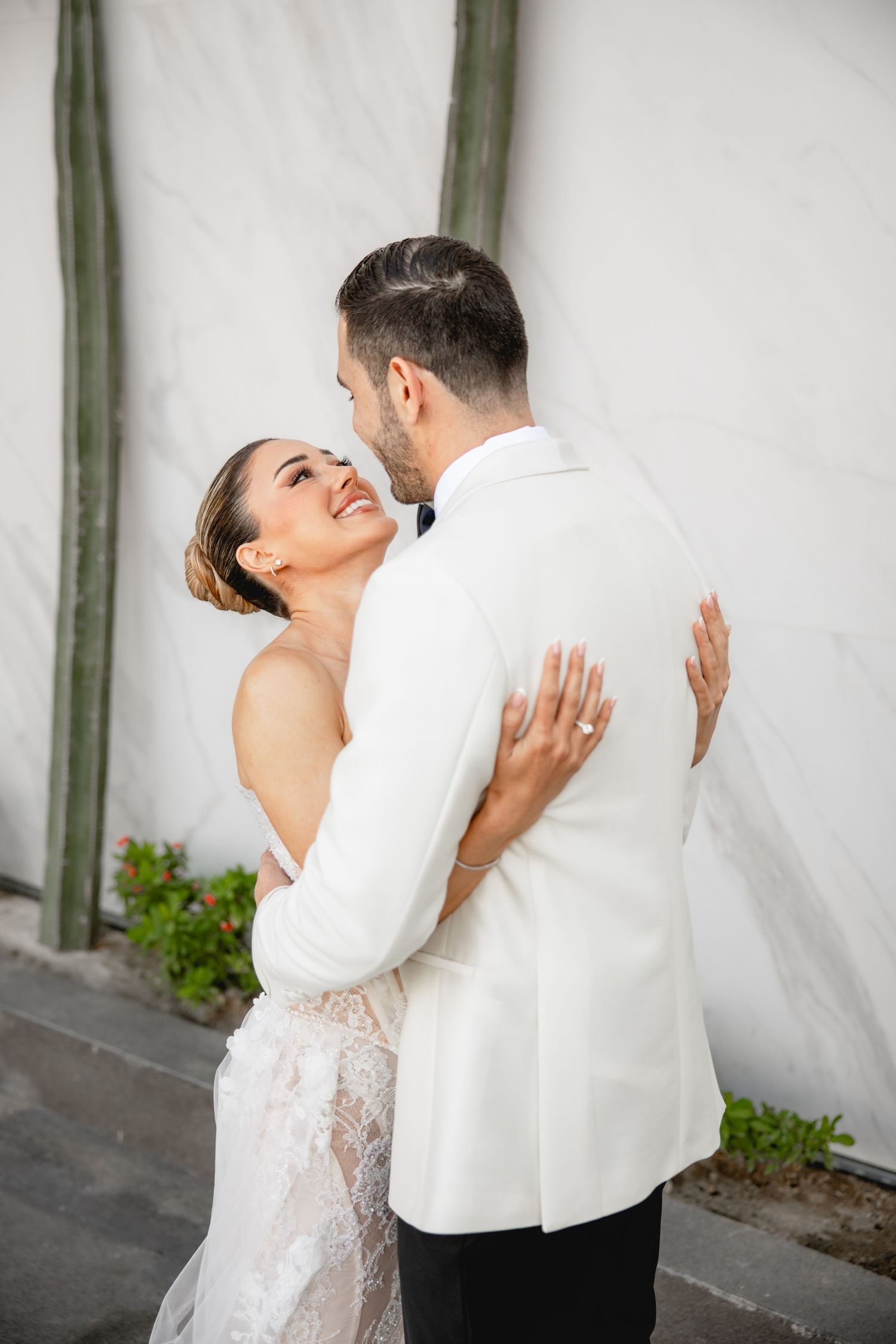 Wedding couple embracing in a series of candid moments against a light backdrop.