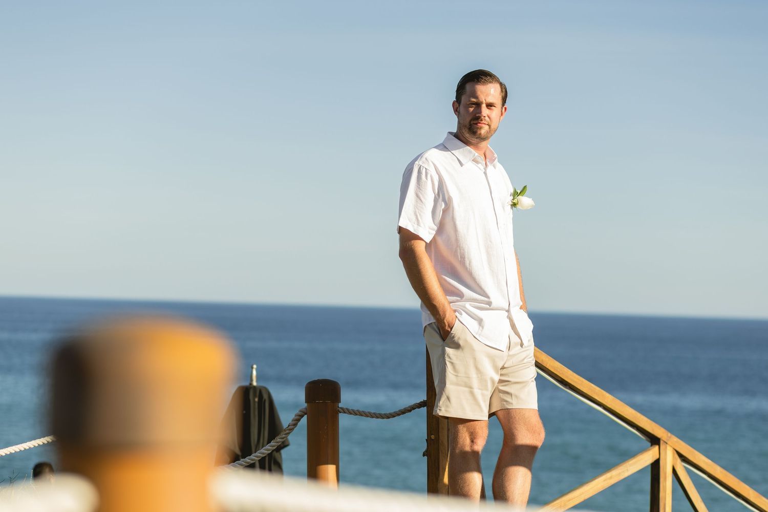 Wooden deck overlooking ocean waves with safety railing.