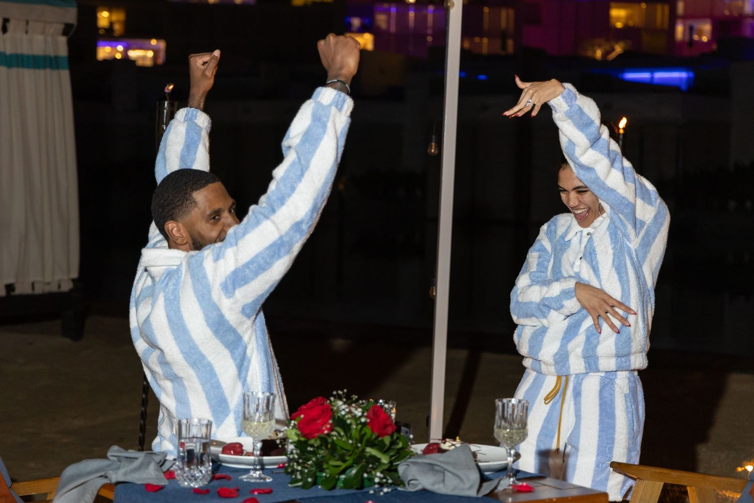 A person in striped white and blue clothing performs a series of expressive dance moves on stage.