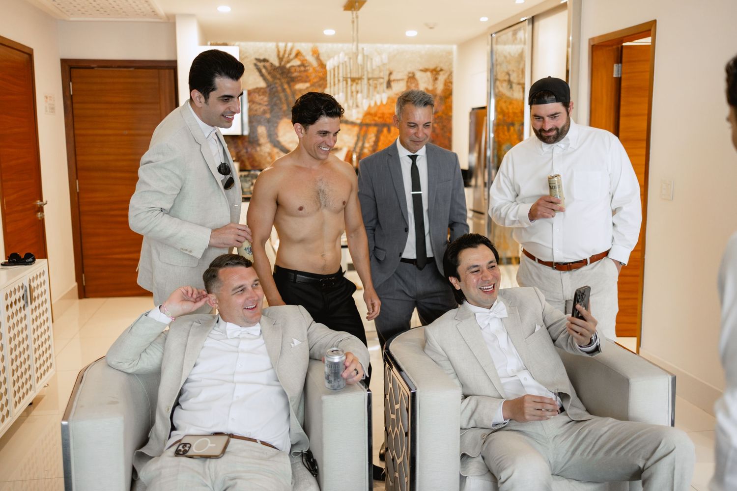 Wedding party relaxing and socializing in elegant indoor venue.