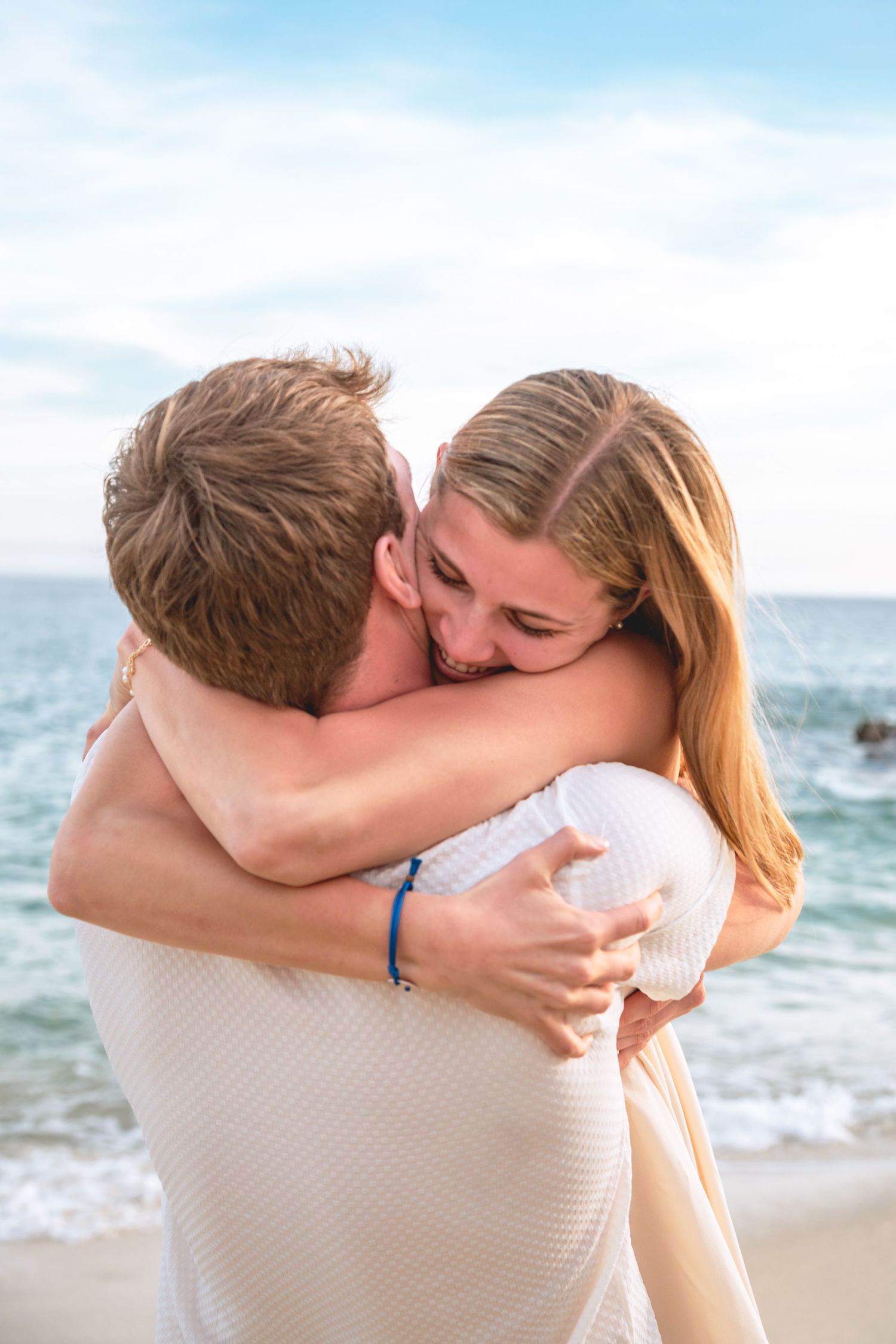 A touching beach proposal scene with emotional embraces captured in sequence against an ocean backdrop.