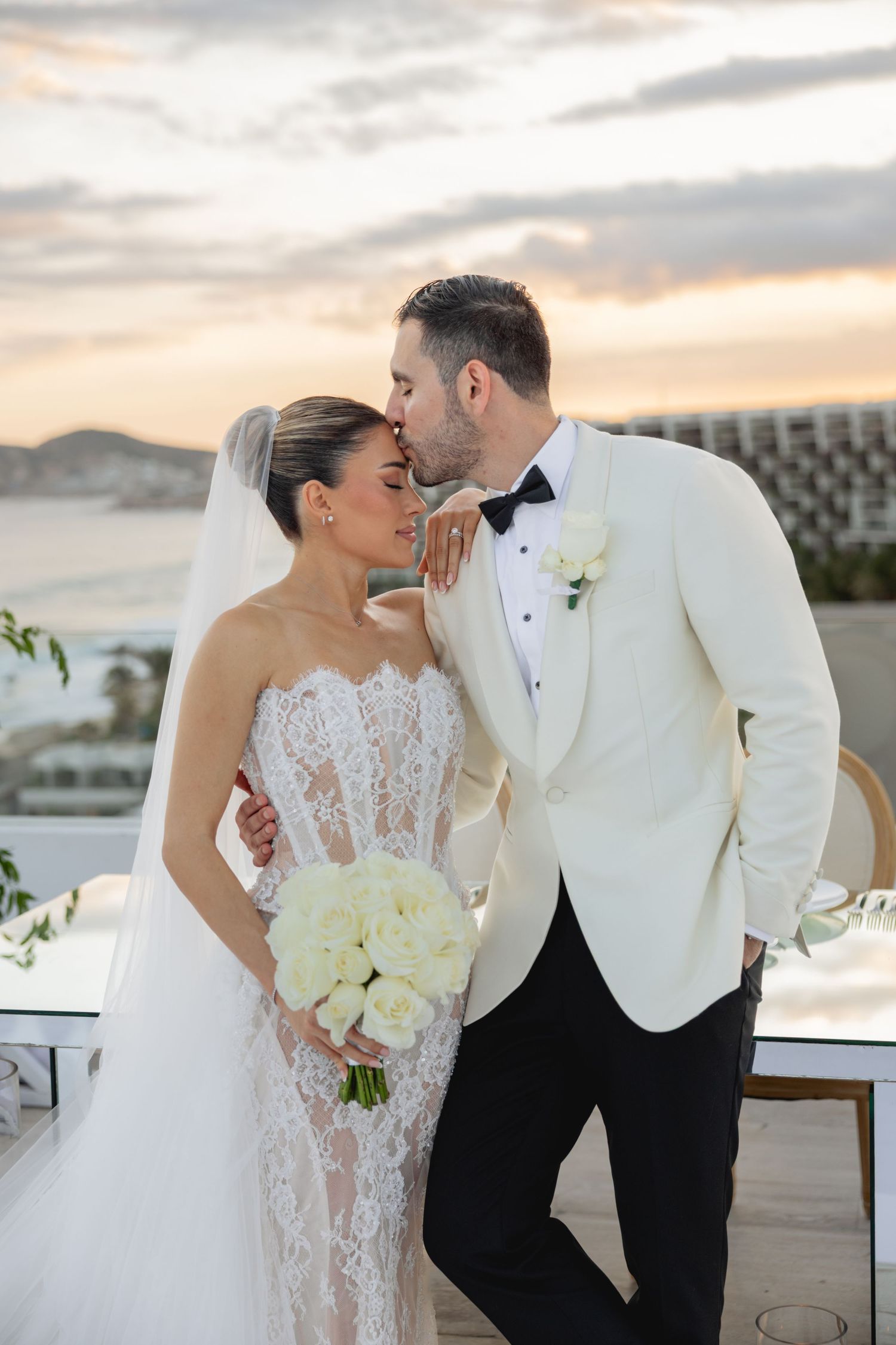 Romantic sunset wedding portraits on a rooftop with stunning coastal views.