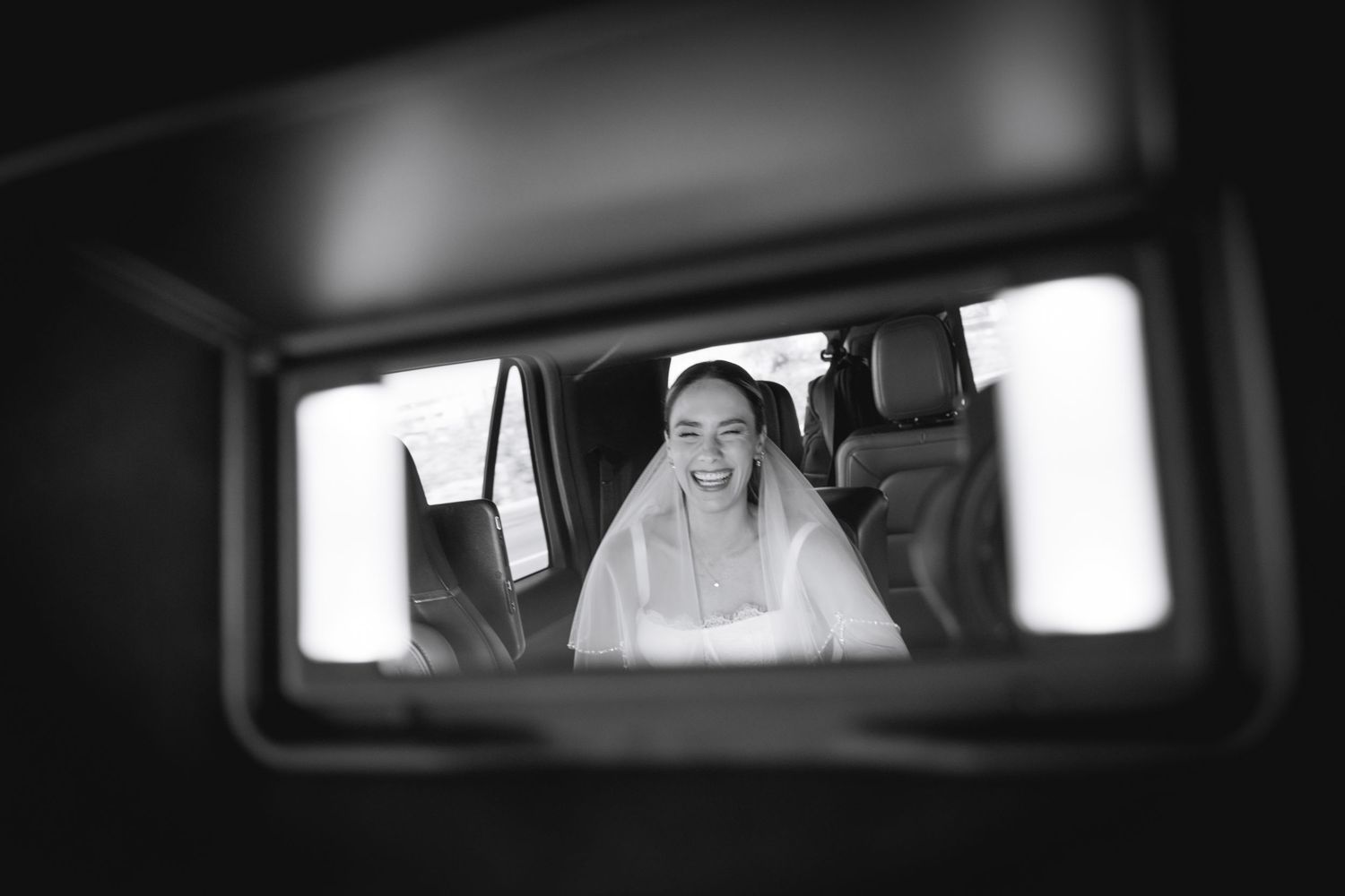 Black and white view through car window showing joyful moments.