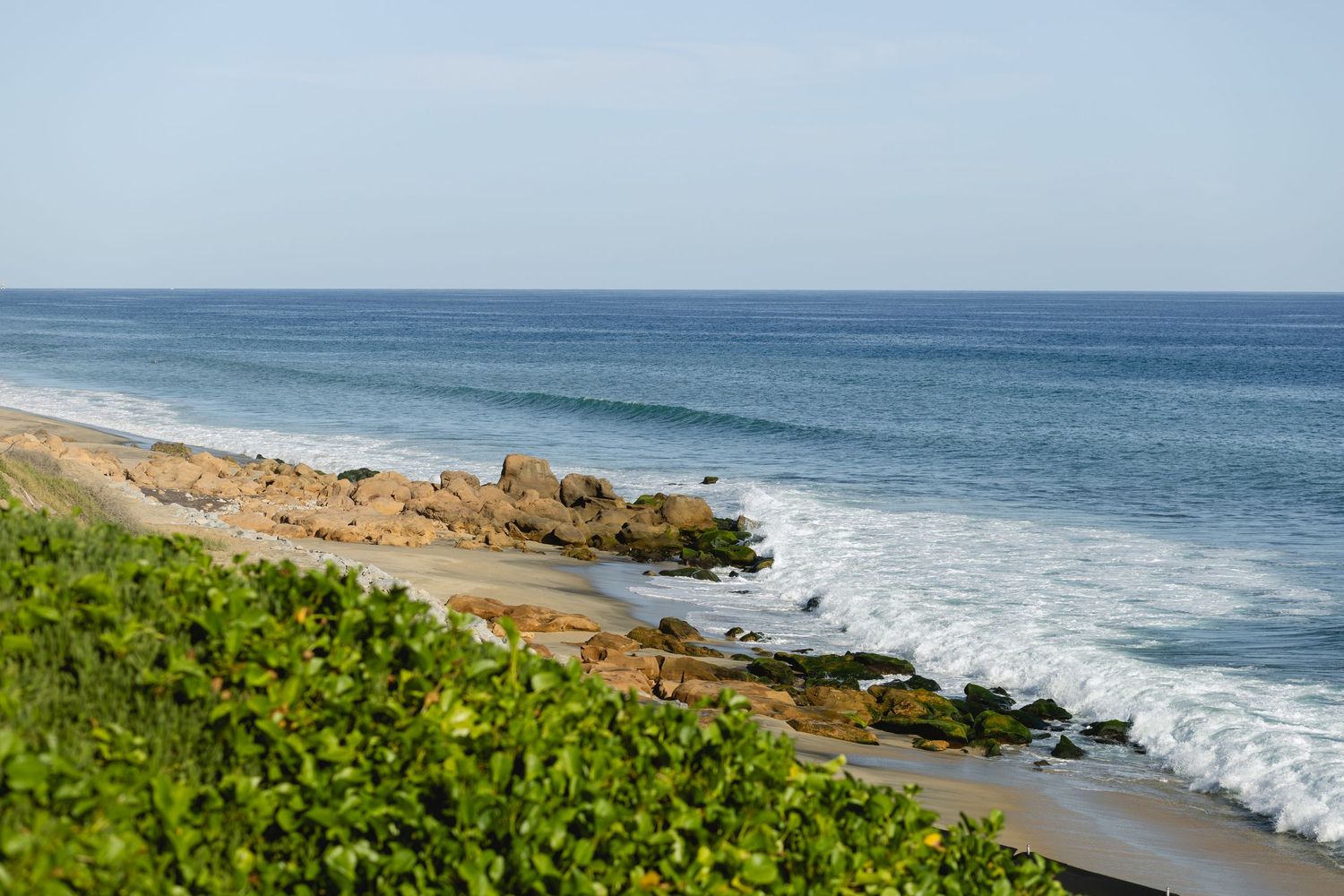 Panoramic view of a coastal landscape with rocky cliffs and crashing waves.