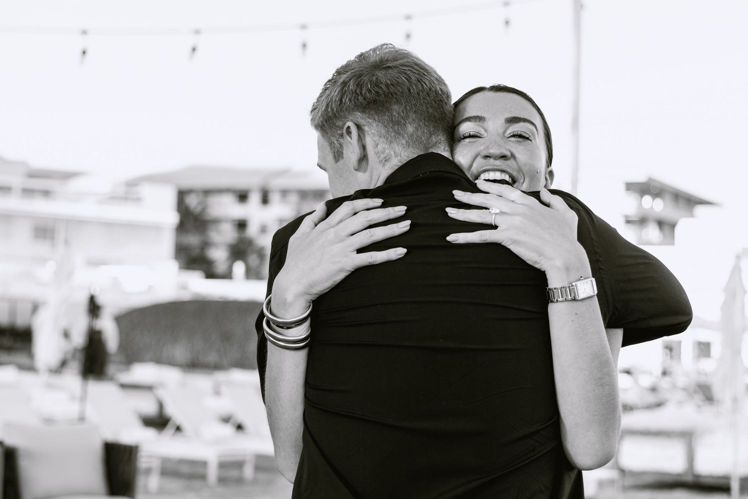 A black and white photo collage shows four intimate moments of people embracing at what appears to be a wedding celebration.