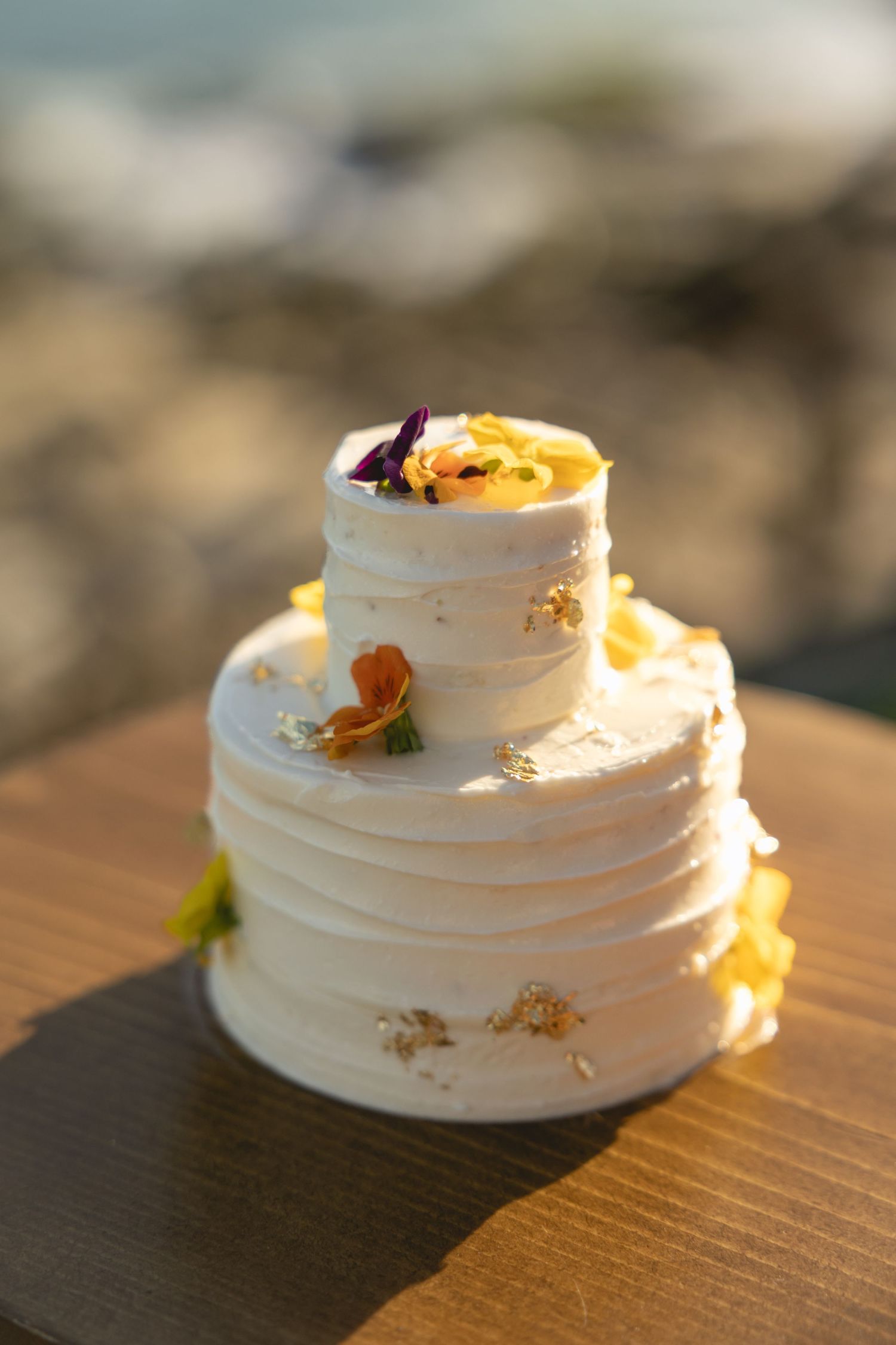 Close-up shots of a white wedding cake with textured frosting and delicate decorative details.