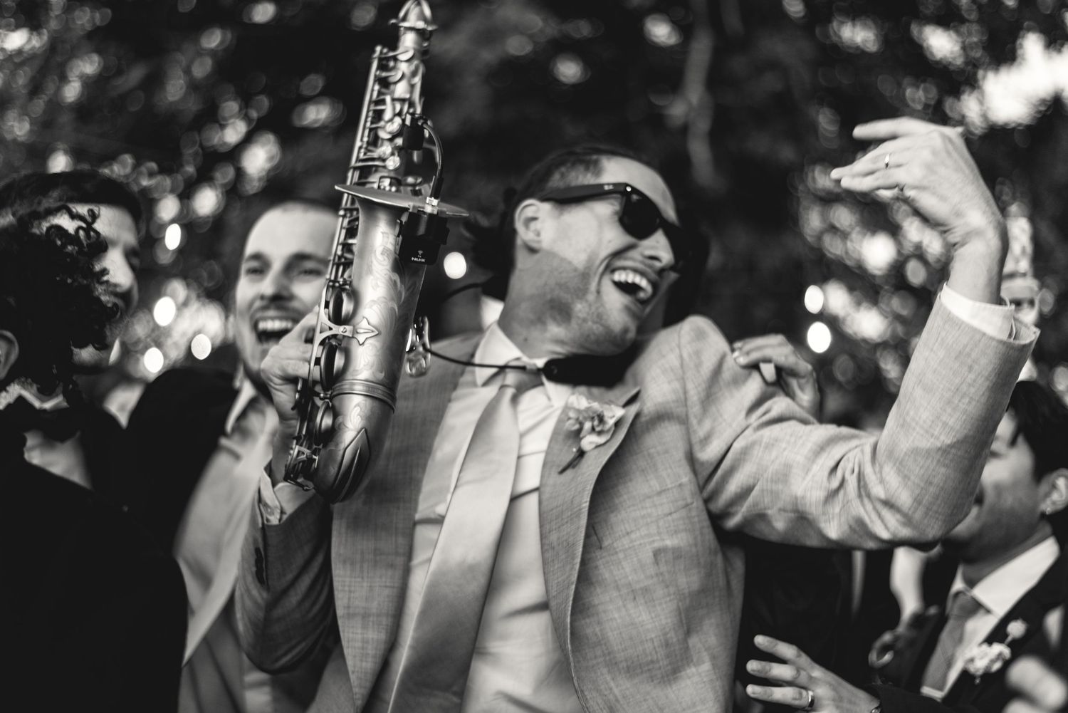 Black and white photo of wedding guests laughing during reception speeches.