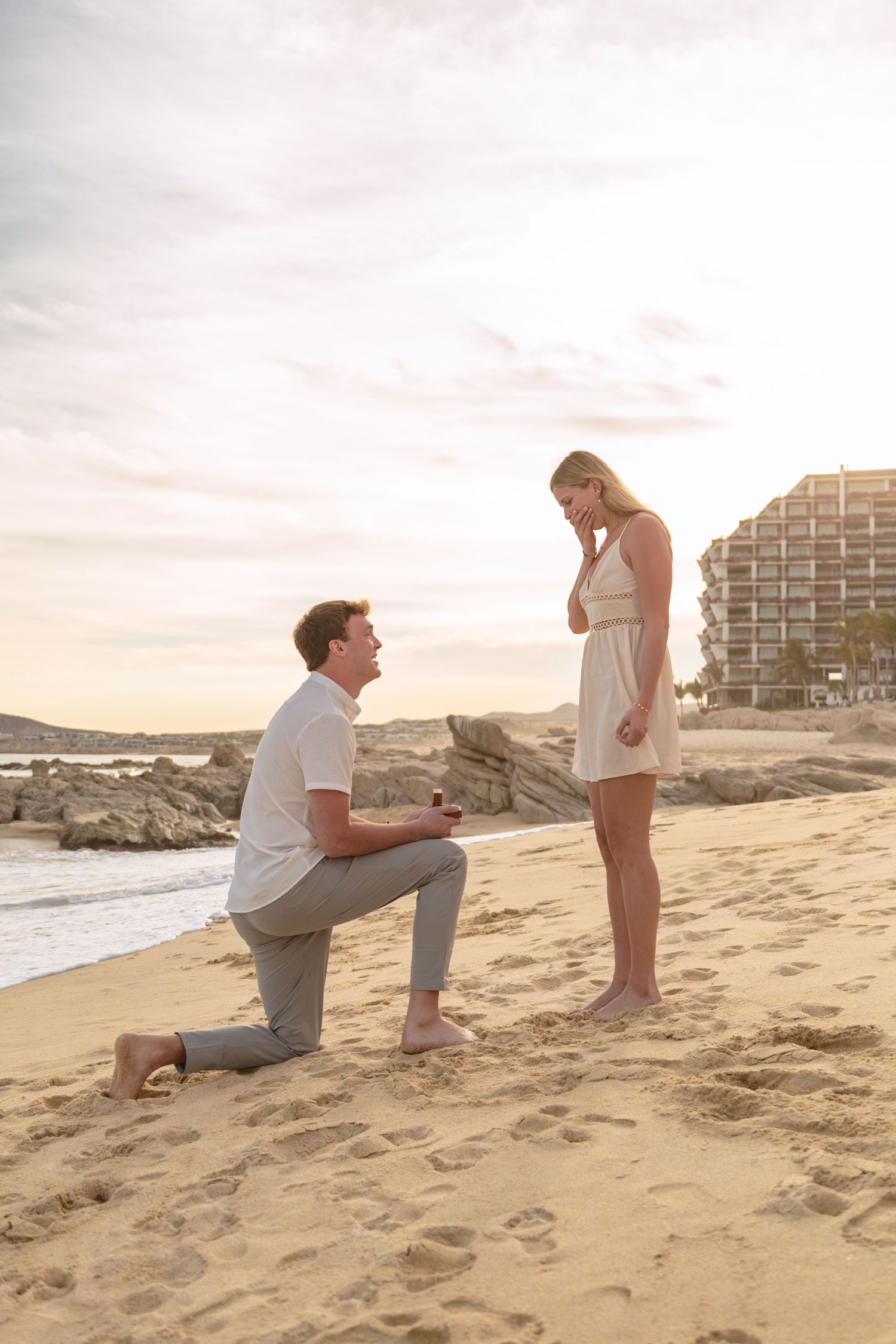 A sequence of photos showing a beach proposal at sunset with two people on sandy shore.