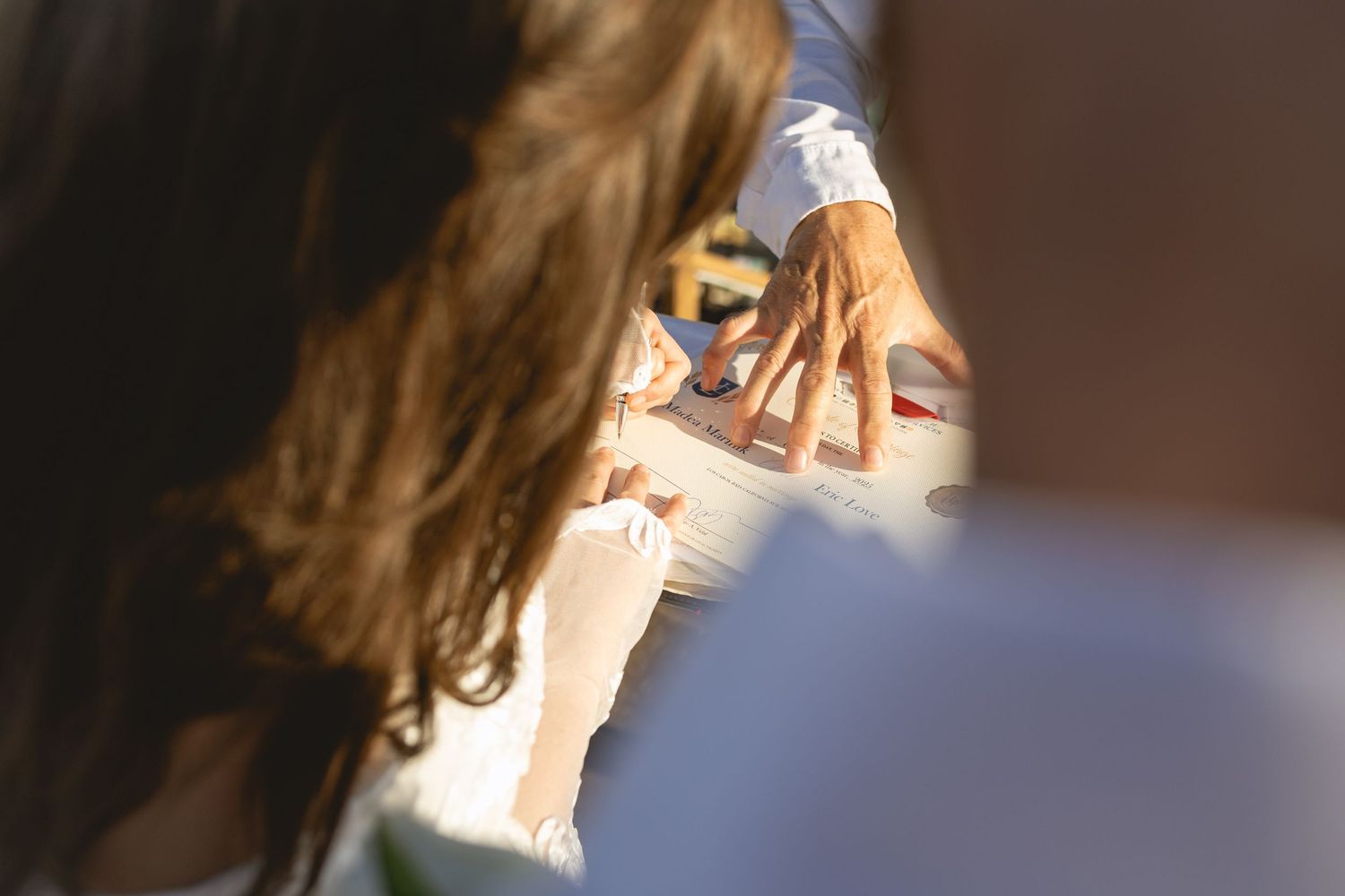 Wedding ceremony participants reading from a document outdoors.