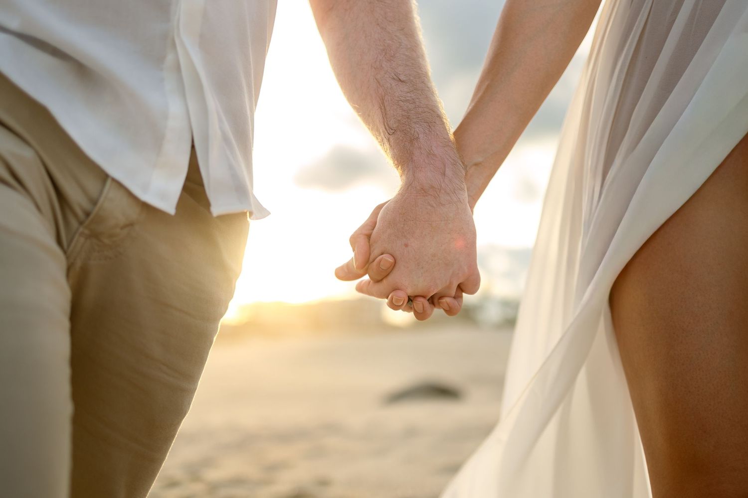 Intimate couple moments captured during sunset beach maternity session.