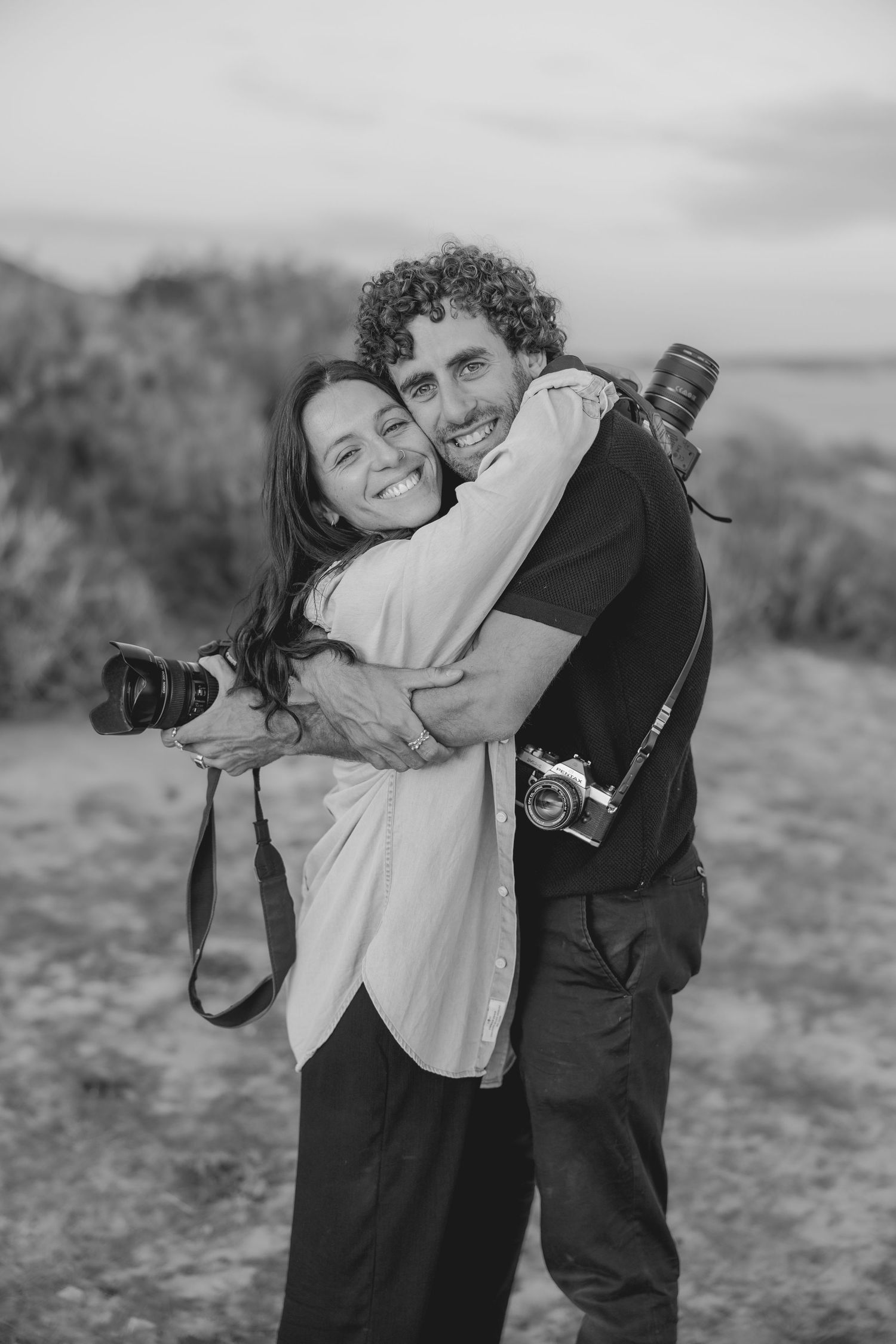 A black and white candid photoshoot showing playful interaction between two people.