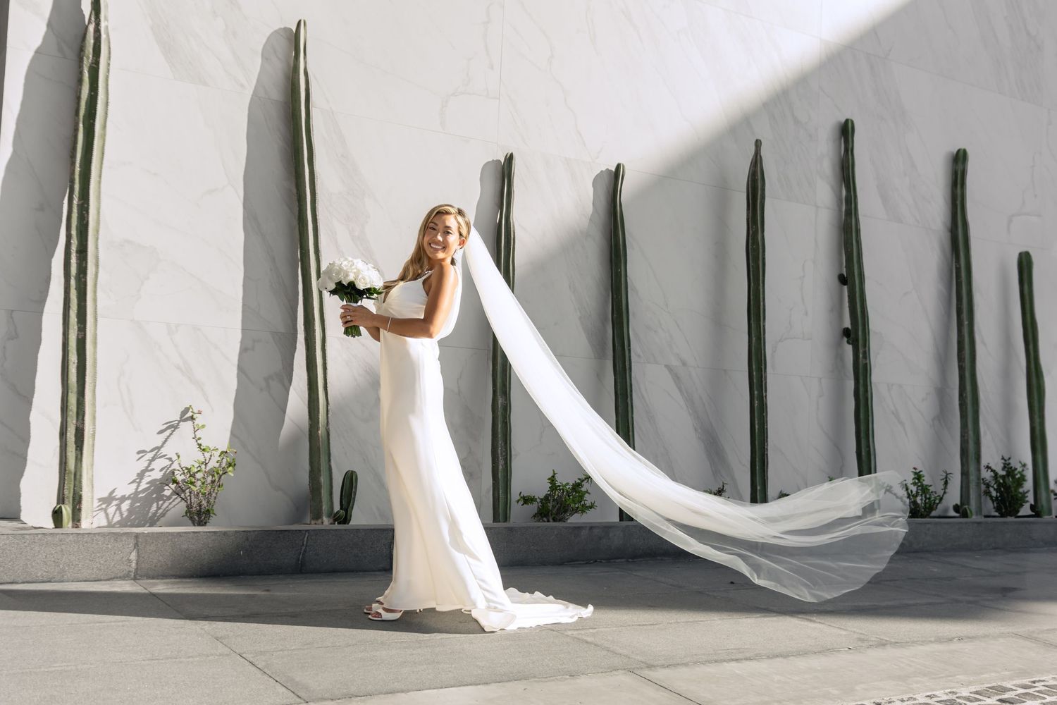 White fabric drapes frame elegant outdoor wedding ceremony space.