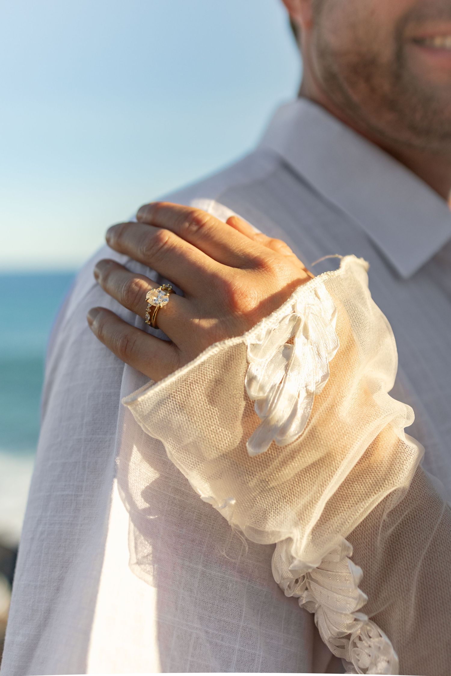 Close-up detail of white ruffled fabric against an ocean backdrop.