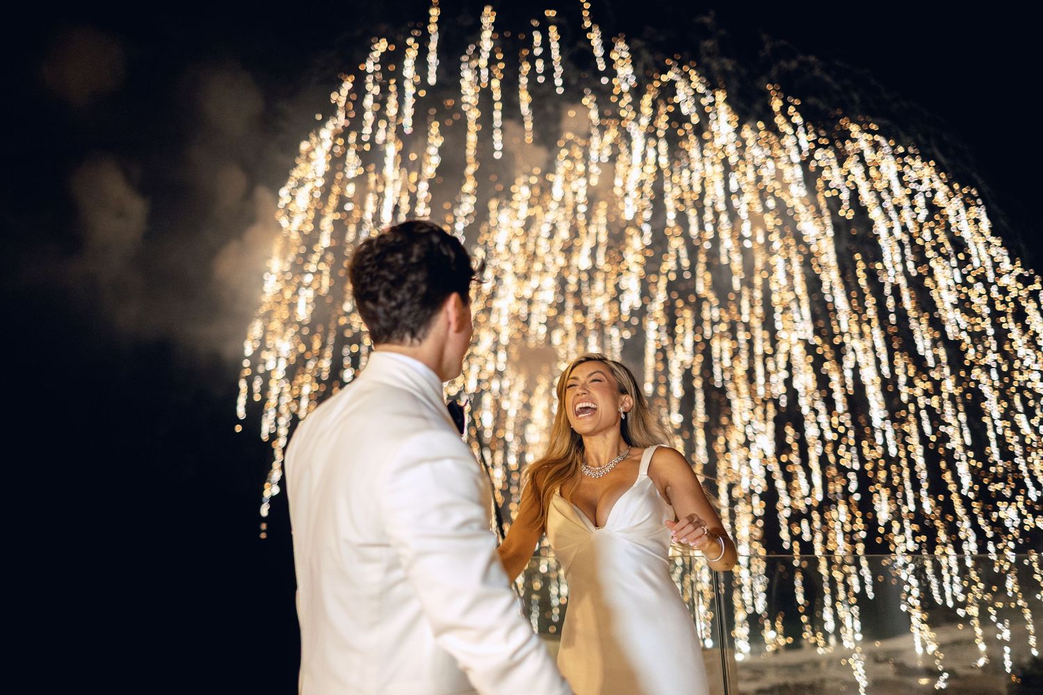 Wedding couple dancing under cascading sparkler lights creating a magical atmosphere.