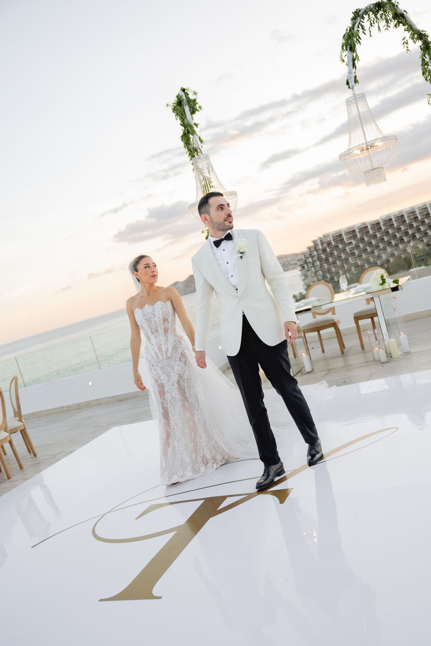 Elegant wedding dance floor with custom monogram design and crystal chandelier decor.