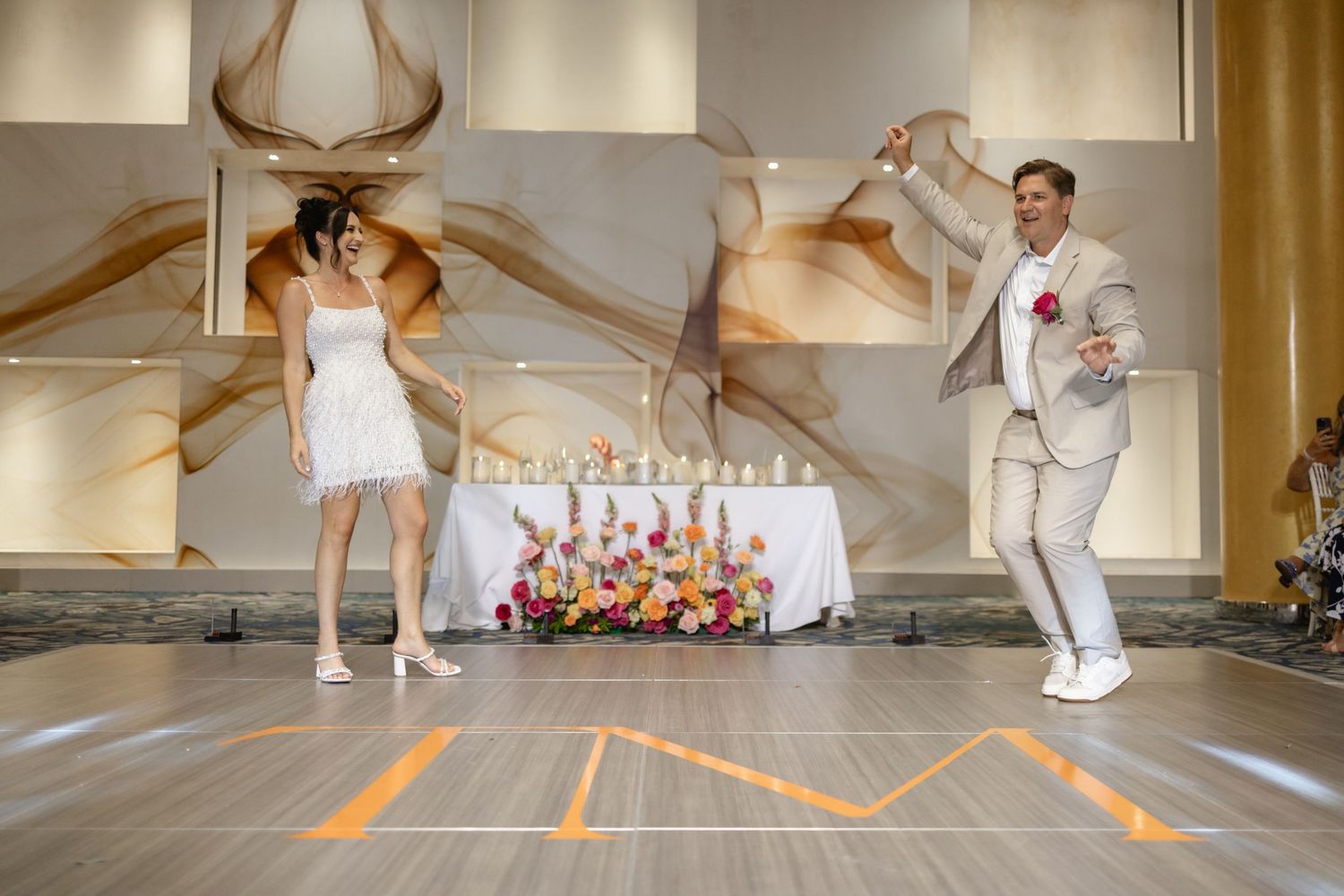 Wedding reception dance sequence in a warmly lit indoor venue.