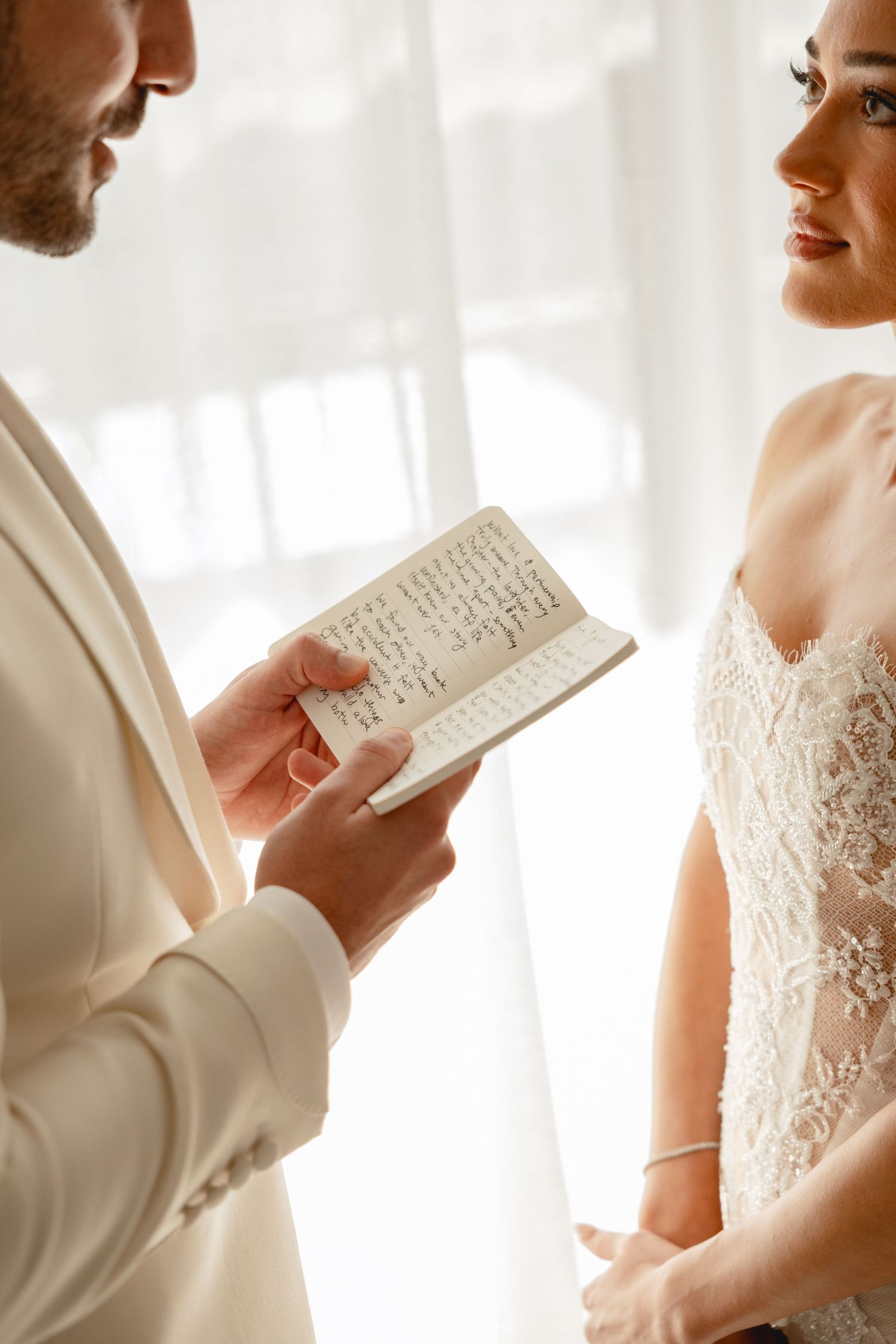 Couple sharing handwritten notes during their wedding first look.