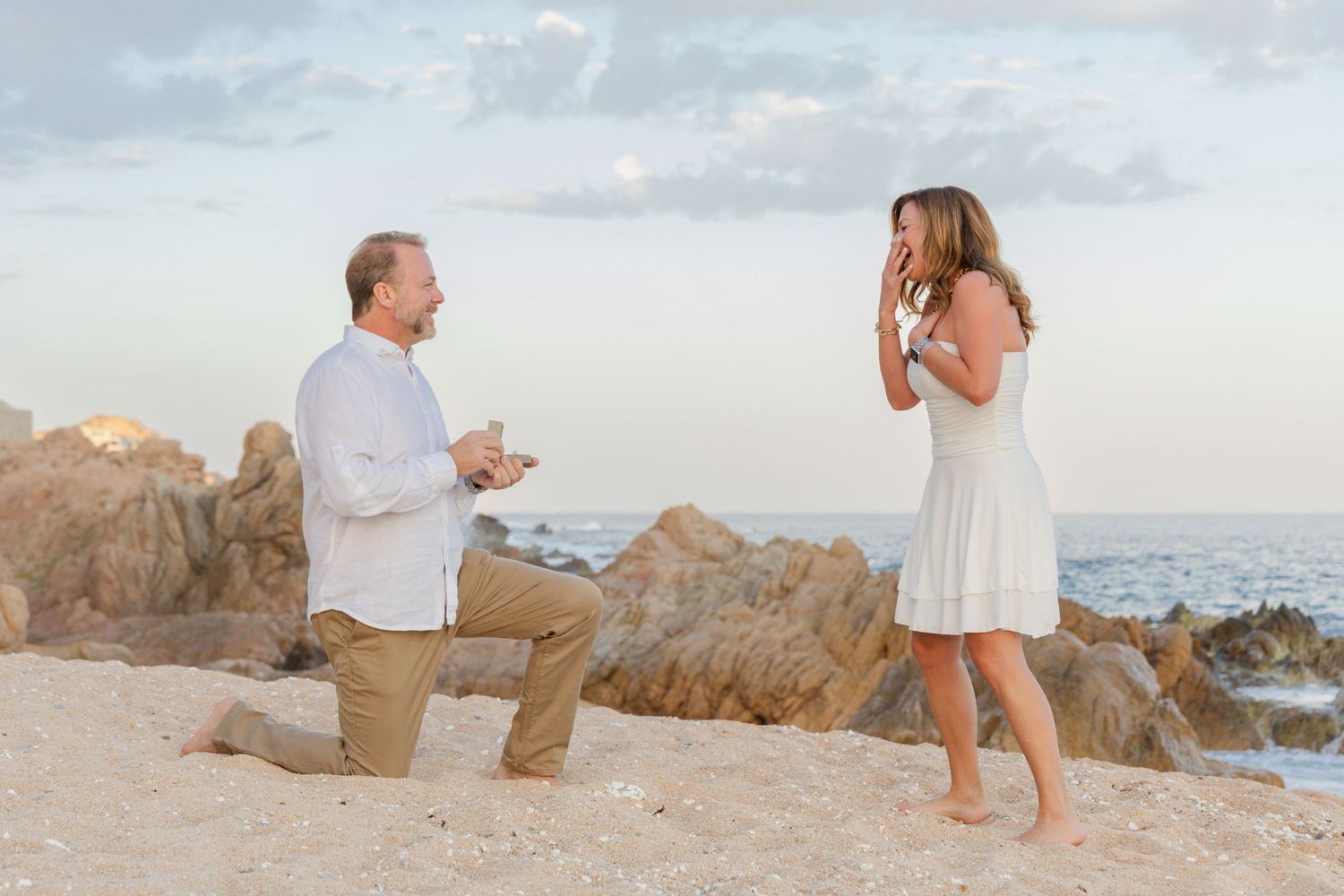 A romantic beach proposal sequence showing a couple getting engaged on a sandy shore at sunset.