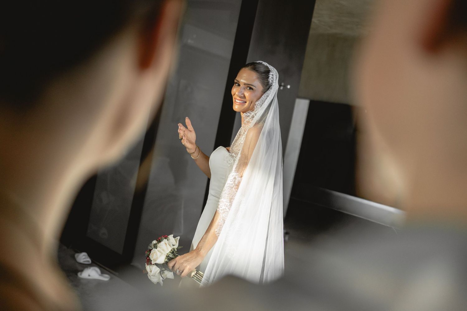 Close-up of hands adjusting a white dress sleeve with delicate details.