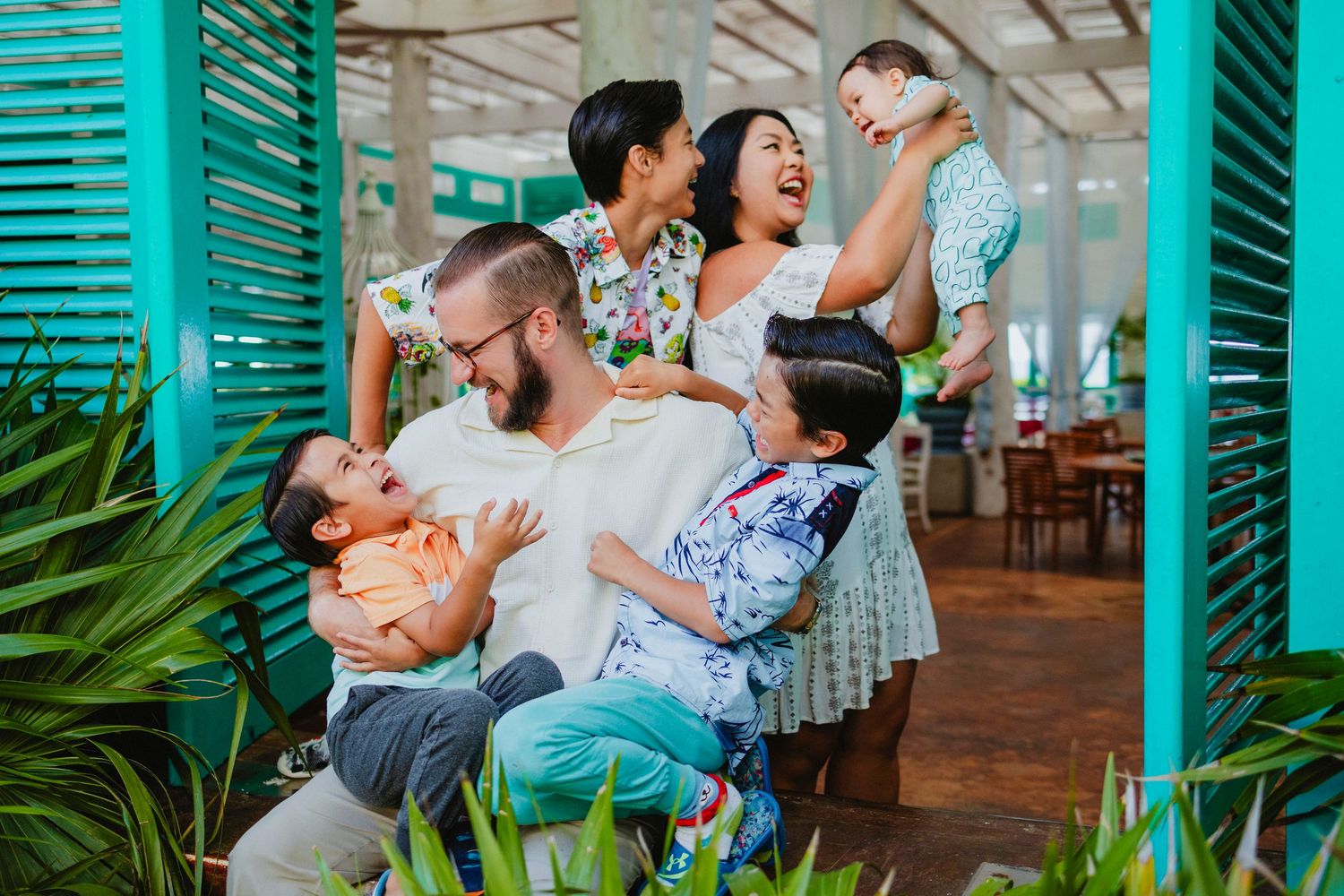 Candid family moments captured in a tropical setting with turquoise accents.