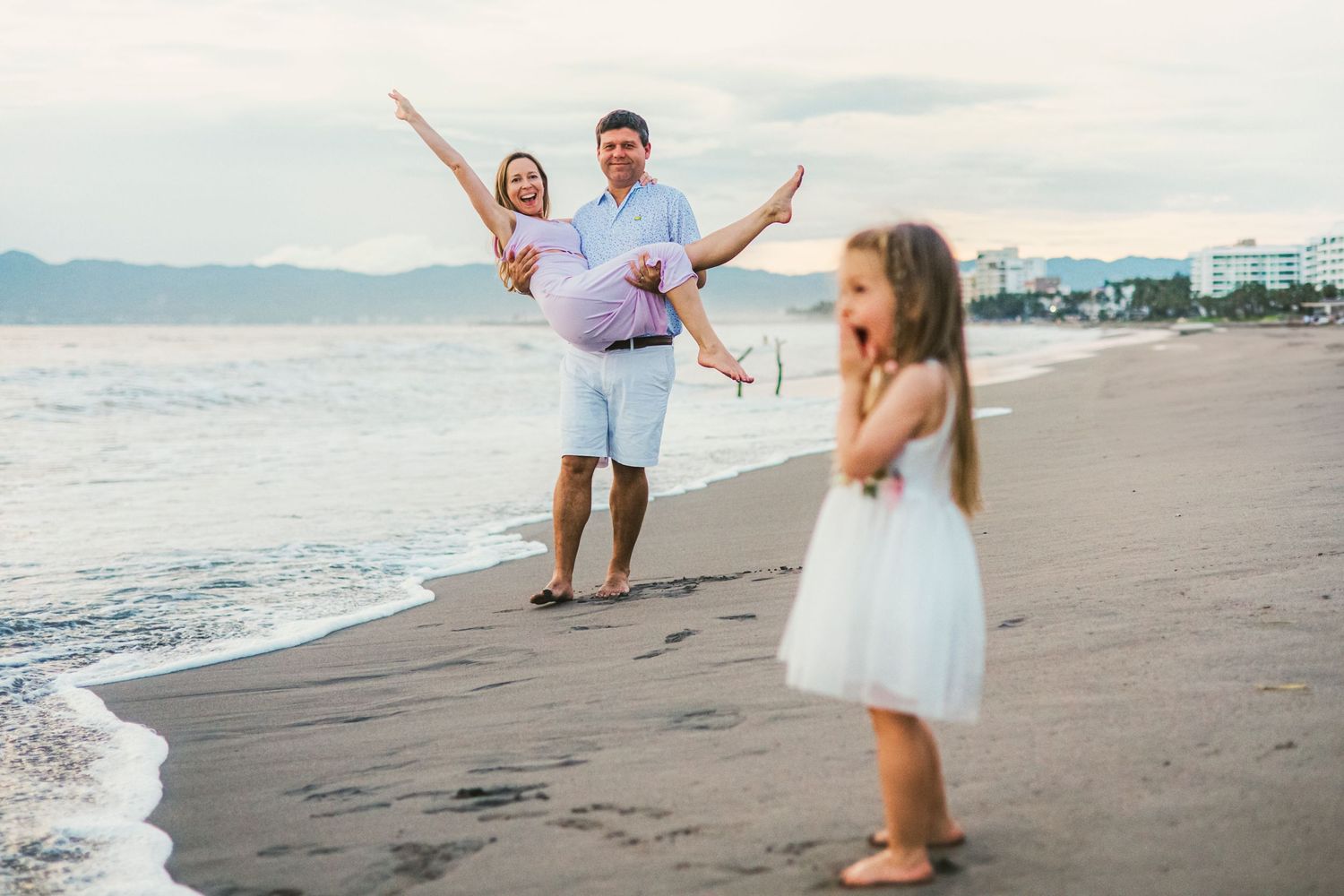 Joyful moments captured during a beach photoshoot at dusk.