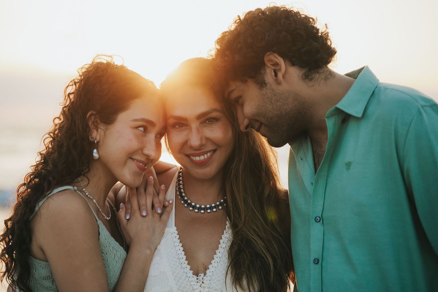 A couple shares an intimate moment together during golden hour sunset in a romantic outdoor setting.