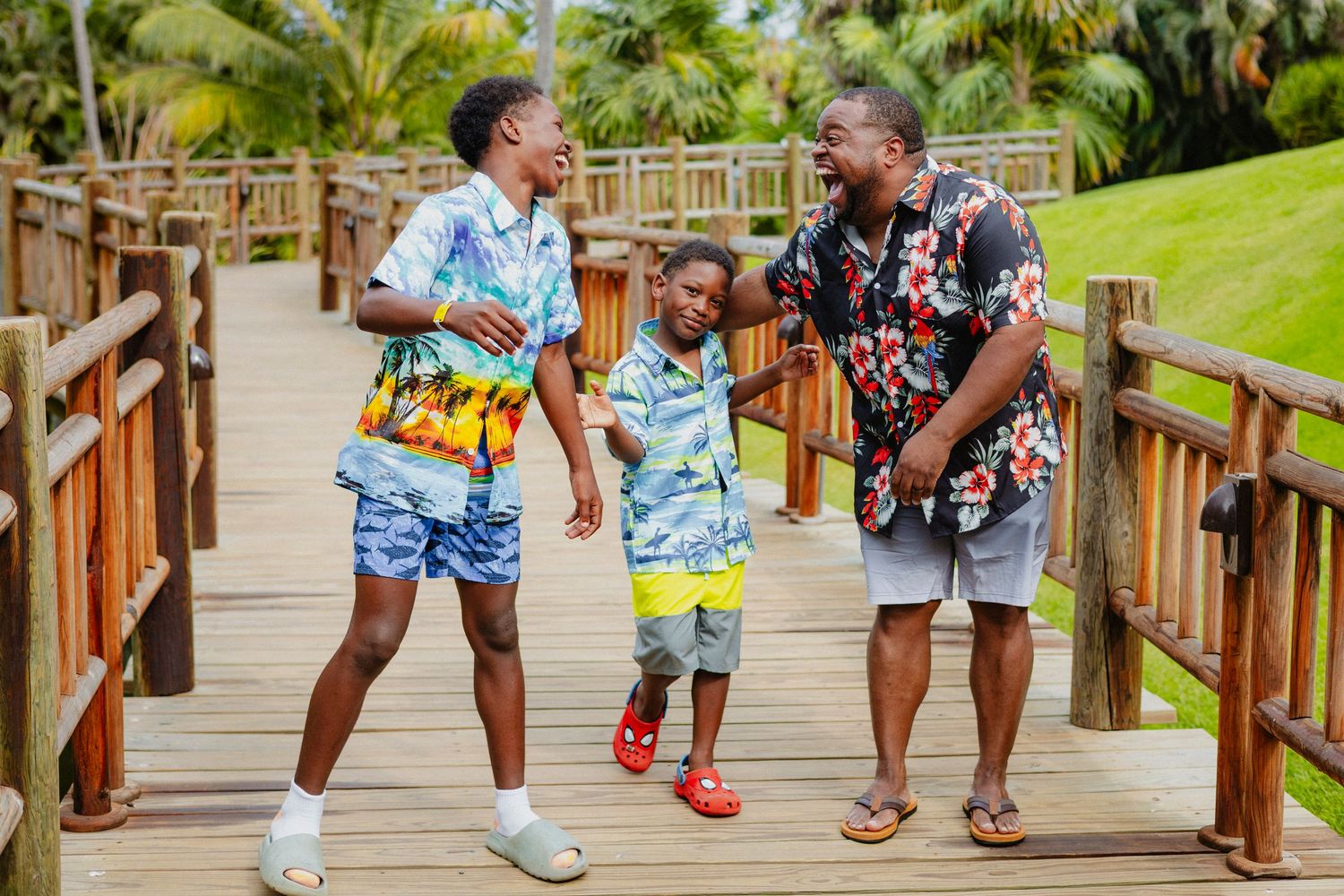 Group walking along a wooden boardwalk surrounded by tropical palm trees.