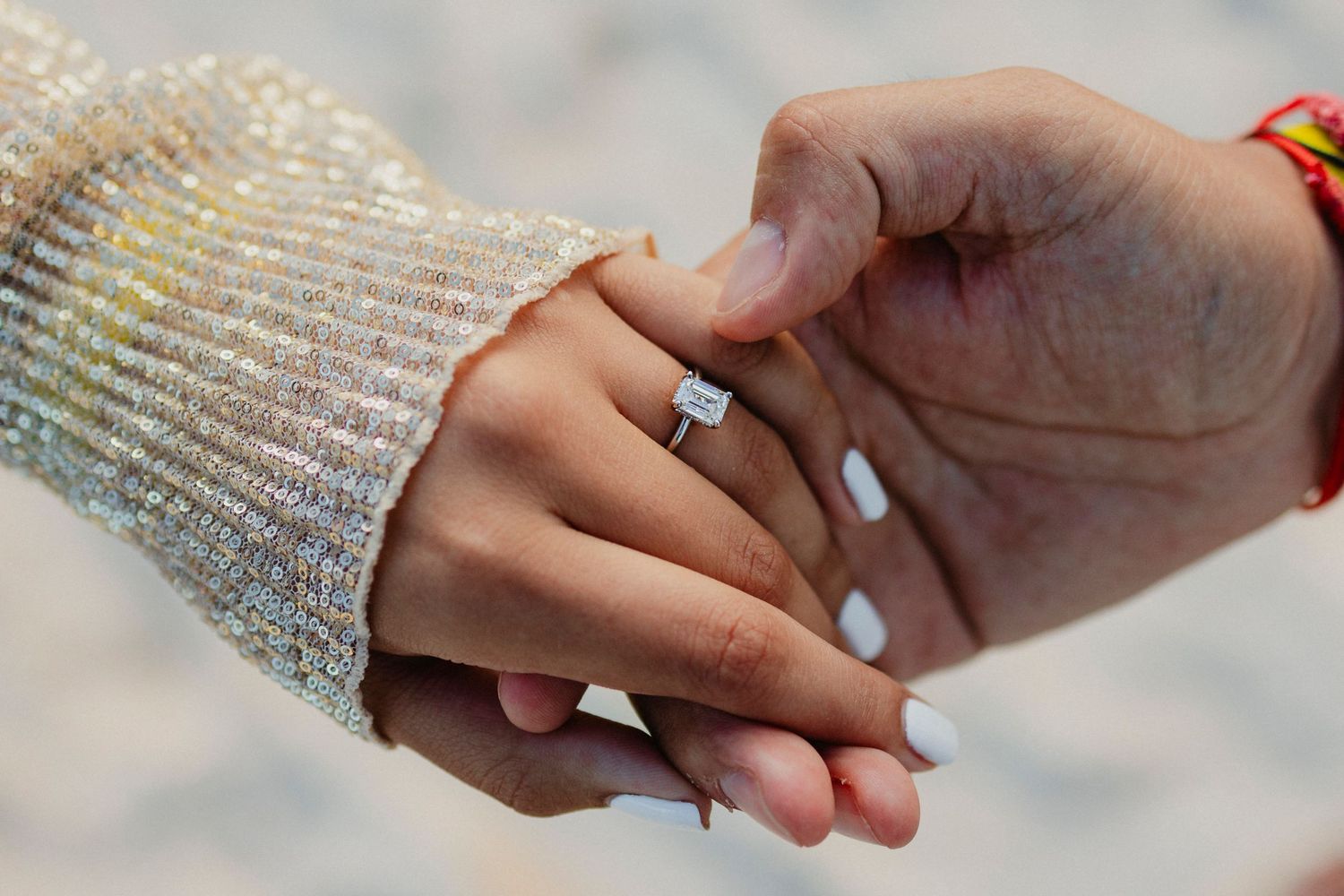 Wedding ring detail shots showing hands and jewelry against a textured background.
