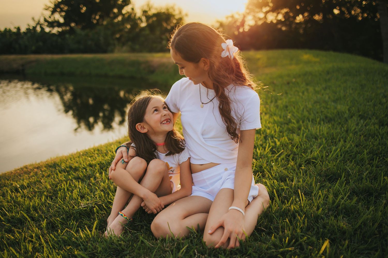 Candid family moments captured on grass during golden hour sunset.