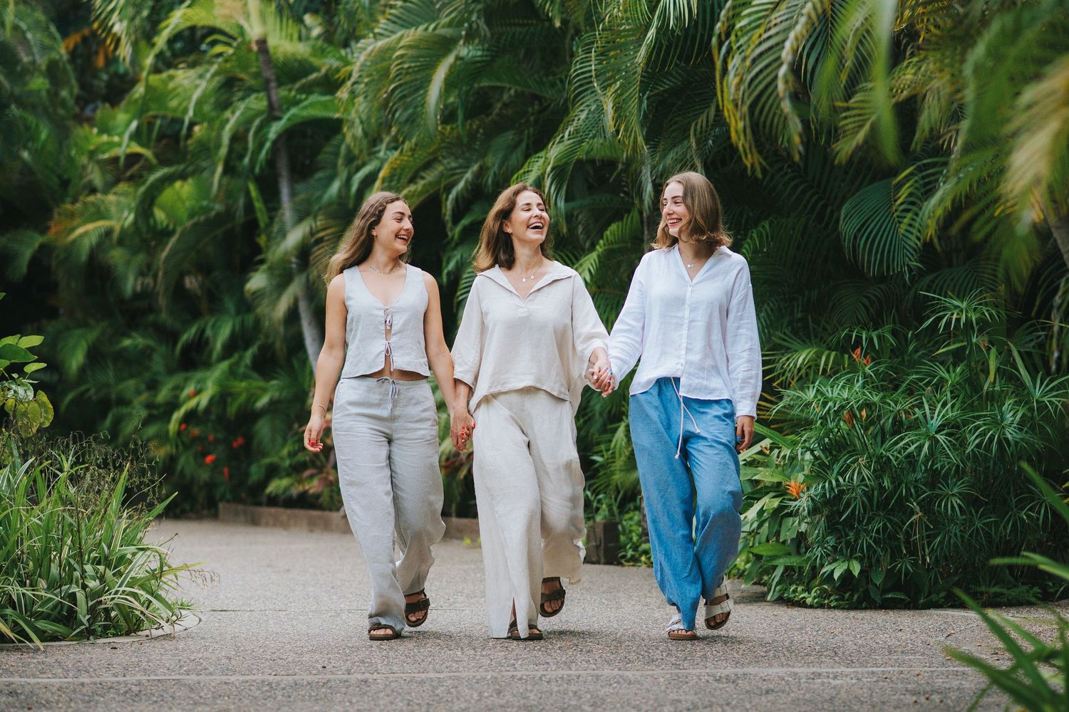 Group walking together on a tropical path surrounded by lush palm trees.