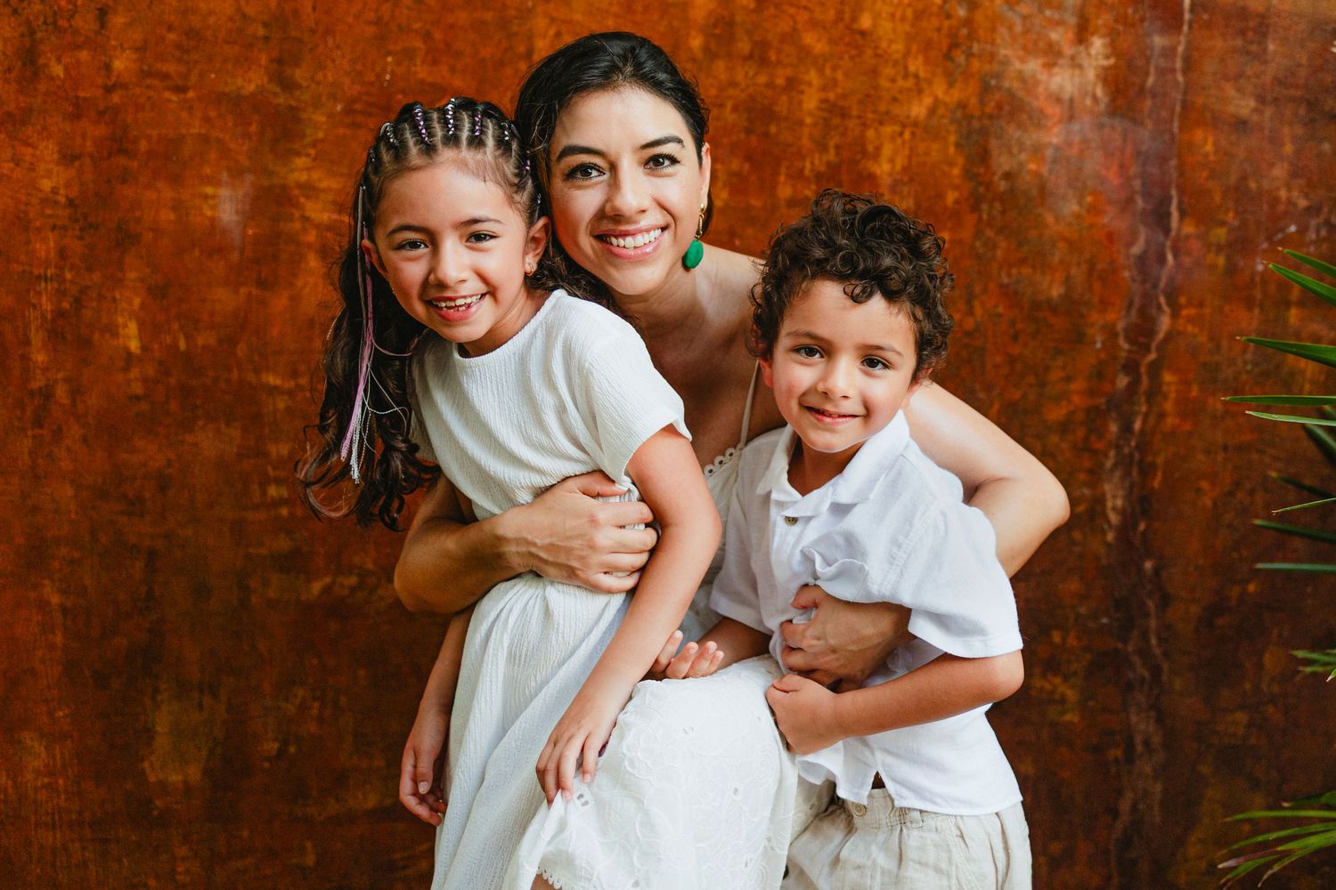 Family portrait session against a warm rustic brown backdrop.