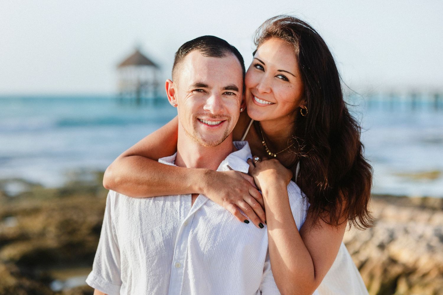 Romantic beach portraits with ocean waves and coastal scenery in the background.