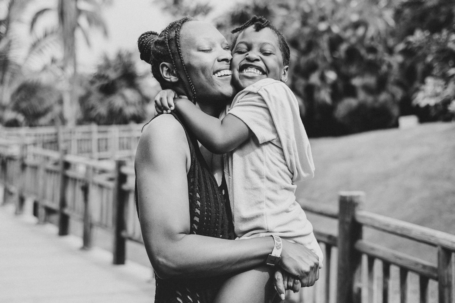 Black and white portrait capturing tender embrace and laughter outdoors.