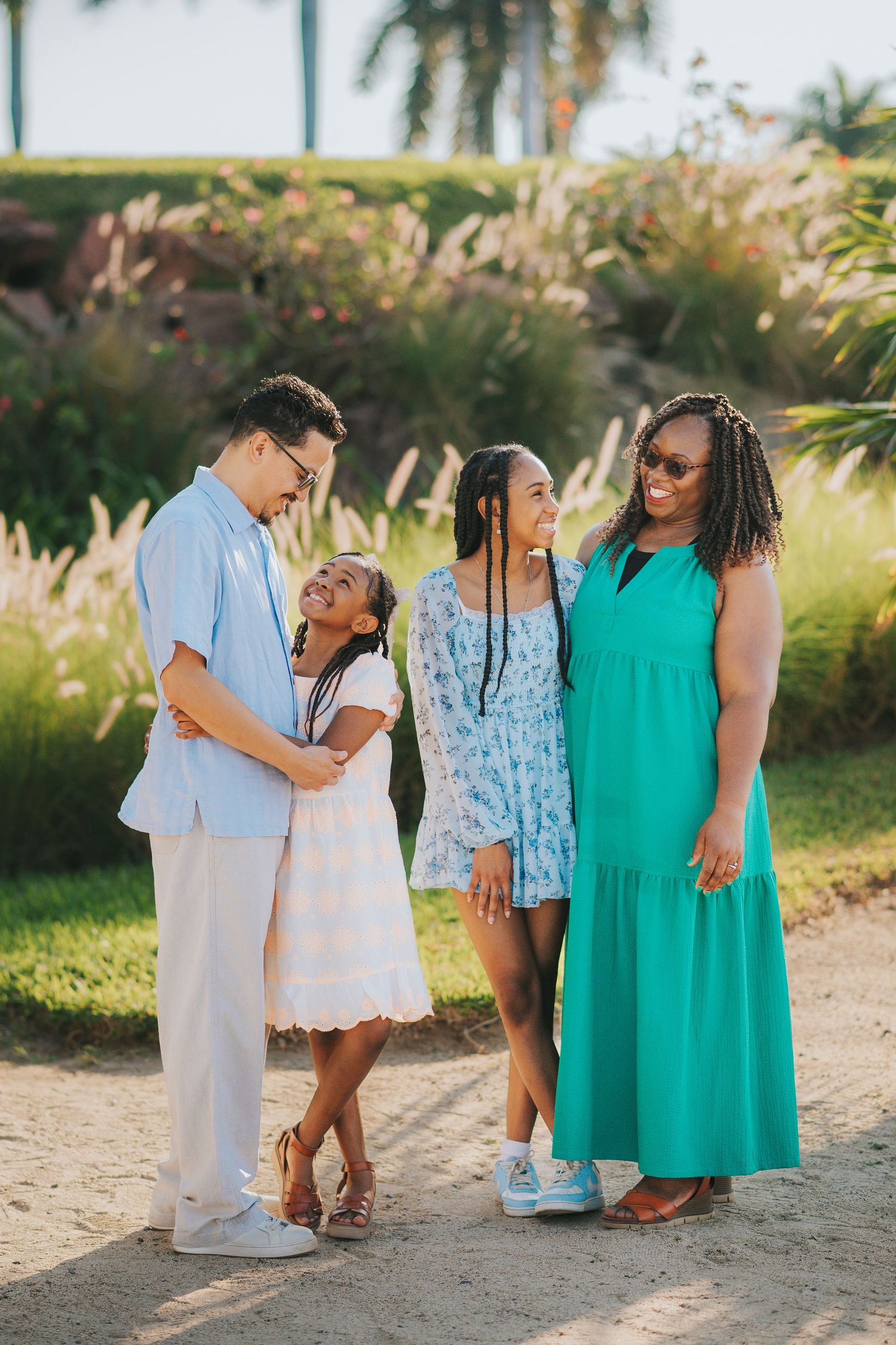 Children and adults in coordinating outfits posing together on a sandy path.