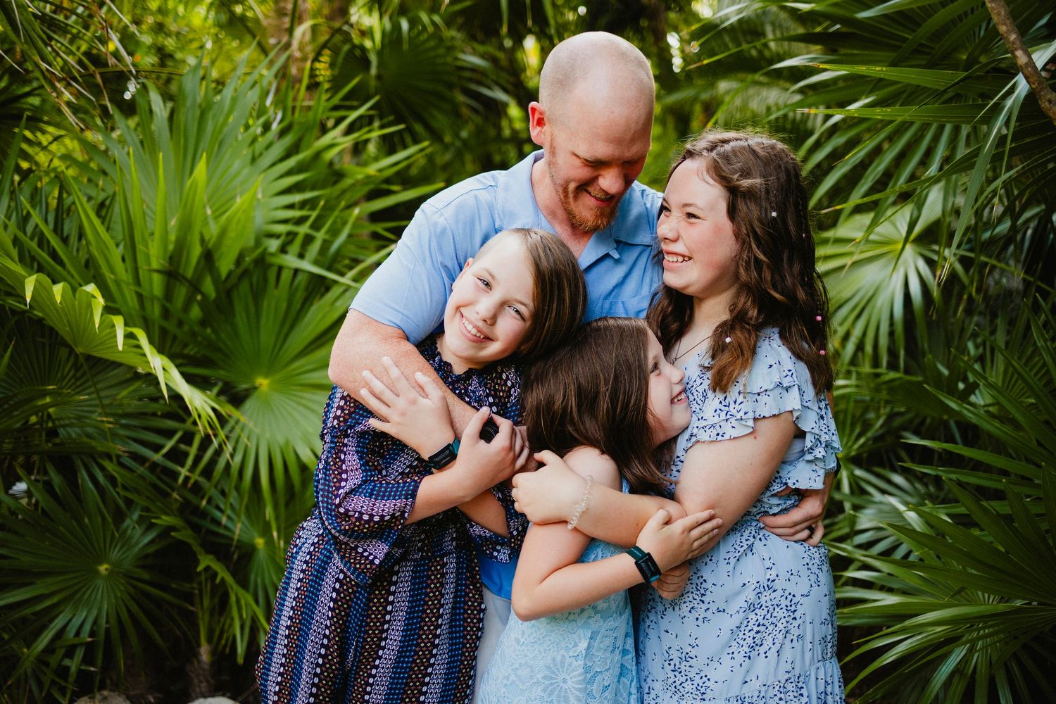 Family sharing tender moments together in a lush tropical garden setting.