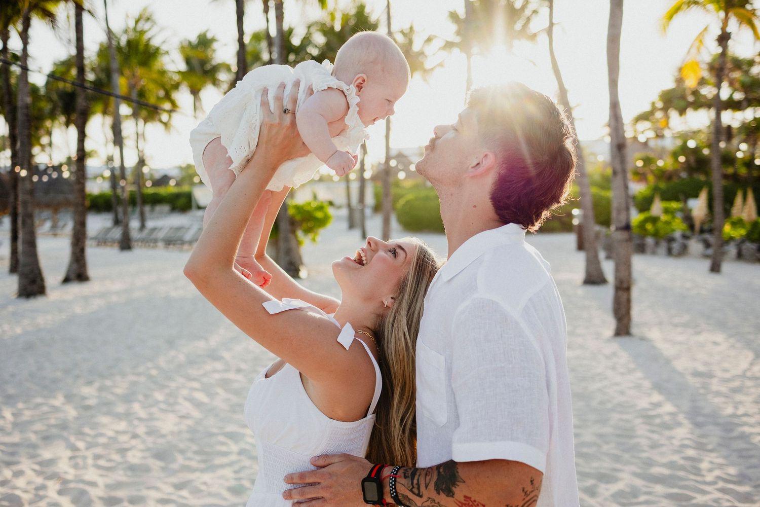 Romantic couple photos on a tropical beach with palm trees at sunset.