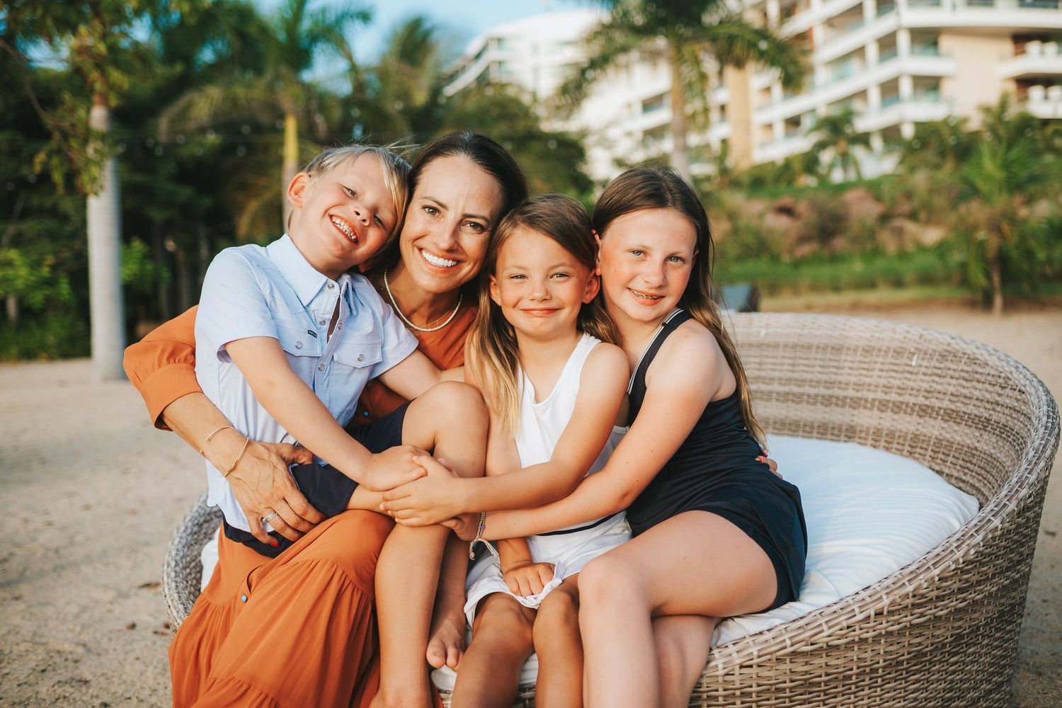 Group enjoying a relaxing moment together on outdoor wicker furniture at sunset.