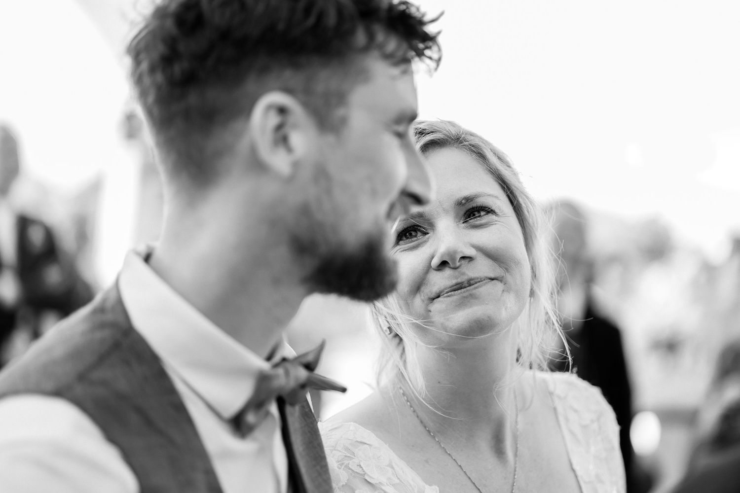 A tender black and white wedding moment captured between a bride and groom sharing a loving glance.